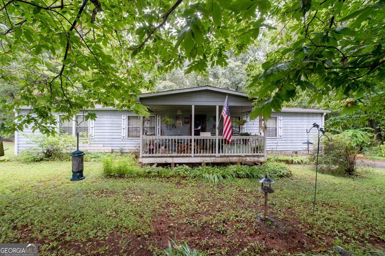 WELCOME to your next HOME with plenty of room to GROW, on over 2.5 acres and a HUGE backyard in the up-and-coming town of Dallas, and the BEST schools and LOTS of good restaurants in Paulding County, Georgia. This property has a country-living kind of feel, with a large and level back yard, a huge workshop & storage barn with an upstairs loft, and there is beautiful stone fire pit in the backyard too, yet it's less than an hour from downtown Atlanta! This spacious 3 bedroom, 2 bath home has been well loved and is ready for a new owner to make it their own. This home has an expansive and open floorplan with a large and almost circular kitchen that would make cooking a breeze. The bedrooms and bathrooms are oversized and yet cozy. There is so much potential on this wooded and level lot, with it's beautiful and lush established landscaping in place already, and plenty of room to do what you please, without any HOA or deed restrictions, either. It could be a great spot for an additional dwelling, a family compound or even a new manufactured home as the infrastructure and utilities are already in place, and yet it is peaceful and convenient too! Call or text today for an easy showing!