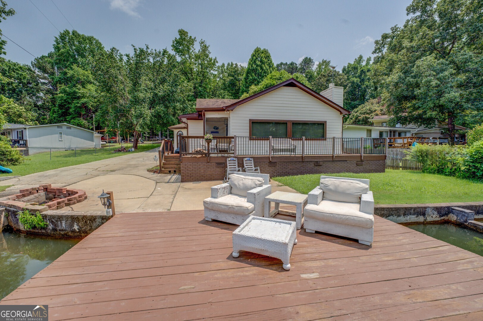 *** MOTIVATED SELLER *** DESIRED LOCATION in a perfect deep-water cove close to Barnetts Bridge! This lakefront family retreat is just waiting for you! With multiple outdoor features, there are countless hours of swimming, sunning, boating, fishing, and family time to enjoy! This property boasts a swim platform with a slide, stationary dock, and floating dock. Wrap up the day on the large open deck, soaking in the glow from the stone firepit and breathtaking views. The seawall and grandfathered-in boat ramp adds unmatched value! The beautifully renovated interior provides an enjoyable day-to-day experience. A covered carport is attached for seamless entry to the kitchen. Can be sold furnished! All kitchen appliances and water/dryer are included with the sale. This stunning Jackson Lake Gem is the definition of move-in ready; the only thing missing is you! OWNER FINANCING OFFERED *** (5.0% WITH 15% DOWN)