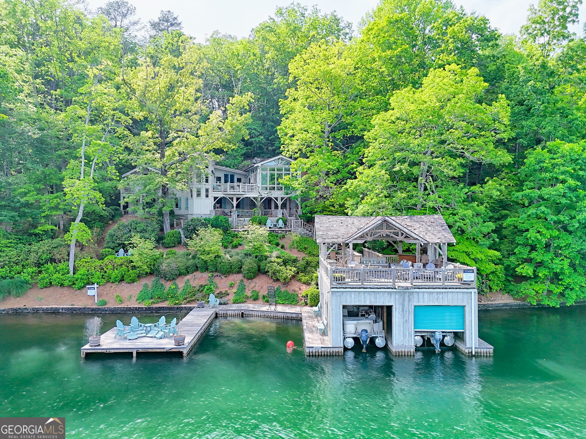 Welcome to 165 Pepe Rd, a delightfully eclectic cottage nestled along the coveted shores of Lake Burton. This 4-bedroom, 4.5-bathroom home is full of character and charm, offering a perfect balance of vintage lake vibes and unique architectural flair. Inside, you will find a relaxed but thoughtful layout with distinctive details and woodsy textures that add a playful yet cozy touch throughout. Each room has its own personality, inviting you to unwind and enjoy the beloved Lake Burton lifestyle. The spacious kitchen opens to a sun-drenched family room---the perfect spot to enjoy your morning coffee or revel in a lazy lake day while savoring the lake and North Georgia mountain views. Step into the whimsical, one-of-a-kind circular living and dining space that feels like something out of a storybook. This unforgettable great room is wrapped in warm cedar shake walls, offering a rich texture and earthy tone that perfectly complements the colorful wood beams arching overhead. The room's round shape creates an inviting, intimate flow---ideal for cozy evenings by the fire or lively dinner parties with friends. A generous primary bedroom and a breezy alfresco porch round off the main level amenities, creating the ideal setup for idyllic lake living. Head down the nautical-themed staircase to the terrace level, where you will find a sizeable ensuite guest bedroom, a second guest bedroom, a bunk room, and a flex room, as well as an ample covered porch to take in the tranquil surroundings. Outdoors, enjoy the best of lake life with a 2-story, 2-stall boathouse featuring a fireplace and a generous swimming dock that's perfect for sunbathing, swimming, or your next cannonball contest. Situated on the edge of a peaceful cove with gorgeous open water views, 165 Pepe Rd is the ultimate retreat for those who appreciate authentic lake cottage charm with a fun, eclectic twist. Conveniently located just a mile from Waterfall Club and less than 15 minutes from downtown Clayton for easy access to award-winning dining, boutique shopping, and excellent grocery and pharmacy options. Come experience the laid-back magic of Lake Burton---this one is full of soul and ready to make memories!