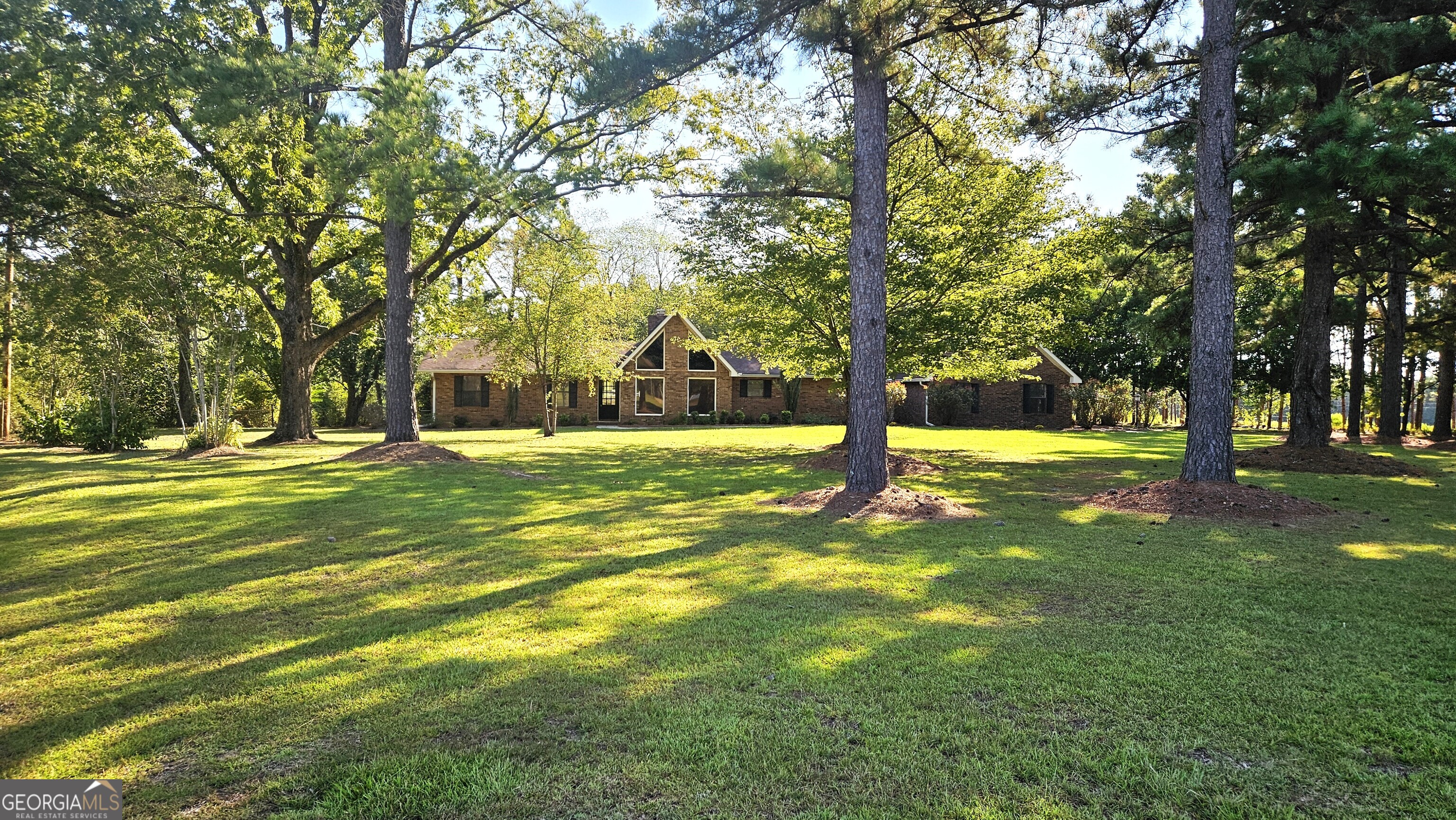 Looking for a place where you can spread out, enjoy country living, and still be close to everything Statesboro has to offer, 338 Jerry Hall Road is the perfect match. Tucked just off Akins Pond Road, this home blends rustic charm with modern updates on a beautiful 5-acre setting. Step inside and immediately notice the craftsmanship-cathedral ceilings with exposed wood beams, floor-to-ceiling windows that bathe the rooms in natural light. The hardwood floors, cedar-lined closets, fresh interior paint, new granite countertops, and brand-new appliances give the home a rustic move-in-ready feel. Outside, the land offers both beauty and function. With more than an acre fenced for pasture, it's ready for animals, gardening, or simply enjoying open space. The 70' x 45' steel building is a standout feature-equipped with power, water, and its own bathroom, it's perfect as a workshop, storage space, or even a future hobby barn. On the back side, three open bays (30' x 20') provide convenient parking for RVs, boats, 4-wheelers, or any of your favorite toys.