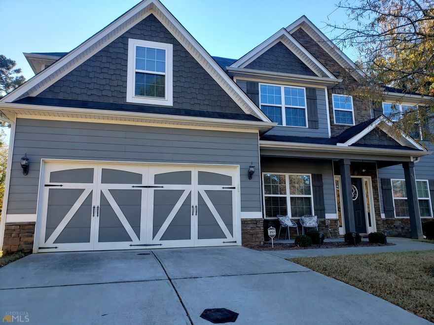 Former Model Home with Upgrades Galore throughout the home situated in the corner lot in sought after Parkside Village! Large Covered Front Porch welcomes you to this meticulously maintained home! As you walk into the front door, you will see Spacious Dining Room with Coffered Ceiling and Wainscoting to your left and Formal Living Room that can be used as office or easily converted to bonus room to your right, leading to the very OPEN family room with Coffered Ceiling, Gourmet Kitchen with Oversized Island with Pendant lights, Plenty of Cabinet and Countertop space, and Stainless Steel Appliances, Granite Countertop, Elegant Hardwood Floor throughout the main floor that completes with Guest Bedroom and a Full Bath, Oak Thread Staircase with wrought iron spindles leading to the second floor with Huge Owner's Suite with sitting area, Tiled Shower, Garden Tub and double vanity in the spacious Master Bathroom, Three good sized bedrooms on the other side with full bathroom with double vanity for convenience, Nice sized Media Room or Bonus Room with double door for family entertainment, Private Backyard with Oversized Game Day Porch with stone framed fireplace perfect for gathering, minutes from I-85, schools, shopping, Piedmont Newnan hospital, close to Downtown Newnan, Senoia and Peachtree City. HOA Fee includes Lawn Maintenance.