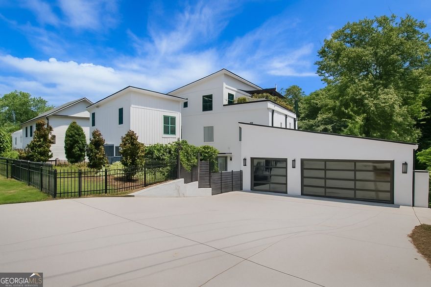 Live in luxury and walk to all that Downtown Woodstock has to offer from this one-of-a-kind, custom built home just off of Main Street. Set on over half an acre, this private courtyard estate features a 4 bed / 4 bath main home with open living spaces, a chef's kitchen and oversized island, high end appliances, and designer finishes. The primary suite sits on its own level with a private sun deck. The newly built separate pool house includes 1 additional bedroom and 1.5 additional bathrooms with a guest suite, bonus room  and a beautiful kitchenette, ideal for multi-generational living, entertaining or extra space for guests. The heated saltwater pool and spa create a true outdoor living space for year-round enjoyment. Additional features  include a home office on the main (could be a bedroom on main if needed) gym, custom mudroom, and glass garage doors for seamless indoor-outdoor living. This is not a typical in-town property. It's a unique combination of land, architecture, privacy, and walkability to shops, dining, music, parks and so much more from Downtown Woodstock's most desirable locations.