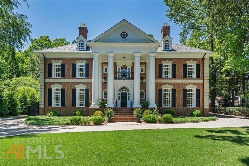 This statuesque Neoclassical brick estate, situated on over an acre of lush grounds in the heart of Druid Hills, is simply extraordinary. Stately porch leads you to an expansive, inviting foyer featuring classic dentil moulding, beautiful light, and 10-foot ceilings. Interior is fully renovated and brilliantly reimagined, presenting a sunlit living room and family room, large dining area with marble fireplace, and designer-sourced Circa light fixtures. Kitchen features slab marble backsplash, hidden walk-in pantry, gorgeous inset custom cabinetry, and incredible island spanning nearly the entire length of the kitchen. Primary bedroom features a vaulted shiplap ceiling, oversized closet with discreet custom storage, and spectacular primary bath with elegant marble finishes. Spare bedrooms include harmonious ensuites, walk-in closets, and generous light. Separate dedicated guest suite with bedroom, living area, kitchenette, and full bath with equally high-end finishes. Massive third story space is ideal for play area or office and stubbed for plumbing for an extra bath. The terrace level is a delight, featuring an enormous media room, large gym, stylish full bath, spare bedroom, and ample storage. 3 car garage; large mudroom with back stairs to the second level. The pi ce de r sistance is the incredibly lush, serene, quintessential Druid Hills lot spanning over an acre, and visible from multiple vantage points on the main and upper levels of this exquisite home. Gorgeous outdoor living space, ideal for lounging and entertaining. This iconic home is a joy to behold. Welcome home!