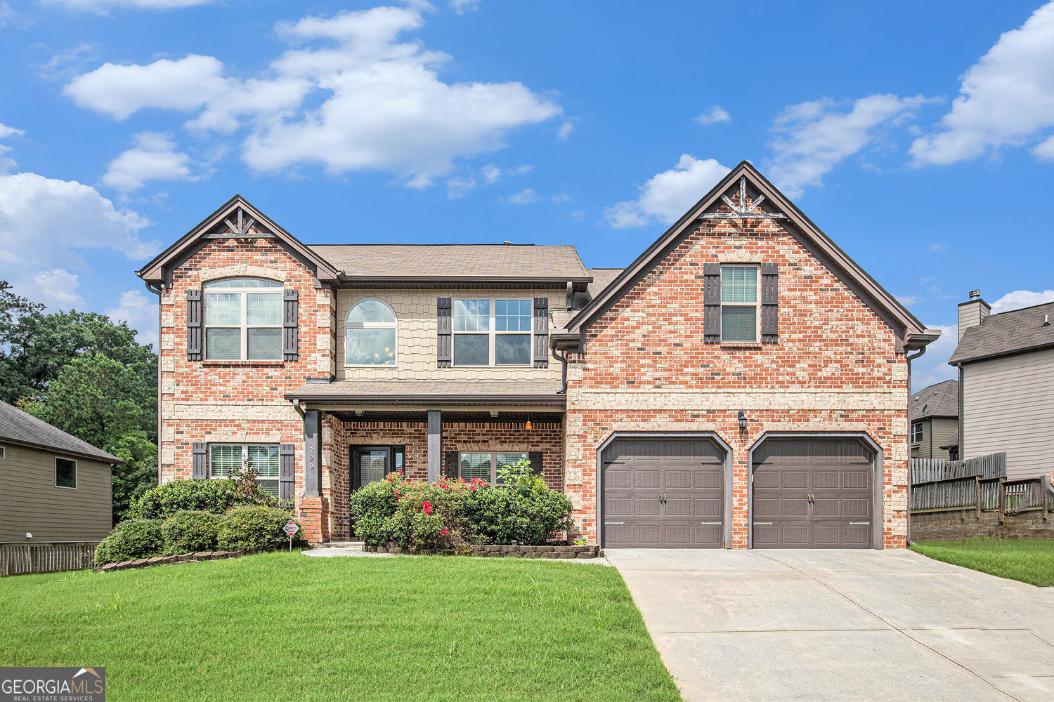 Beautifully maintained brick-front home in sought after Traditions Subdivision in Archer School District. Dramatic two-story foyer leads to the coffered ceiling Family Room with a fireplace. The open concept flows into the Kitchen where you'll enjoy entertaining and preparing meals over granite counters with tile backsplash, breakfast bar, large island, antique ivory cabinets, SS appliances, & a walk-in pantry. Wide-beam hardwood floors throughout the main floor that includes arched hallways to a Living Room/Office, Formal Dining room with coffered ceiling, and guest bedroom. Upstairs the oversized primary suite boasts a huge sitting area and ensuite bath with dual vanities, soaking tub, rainfall shower, and large walk-in closet. Three other generous bedrooms include vaulted ceilings, a private bath, and two that share a Jack/Jill bath. The laundry room is conveniently located upstairs also. You'll enjoy the rocking chair front porch and a fenced backyard with a covered back patio that includes a fire pit for cool winter nights. The home has been recently painted through and move-in ready. Perfectly located with some of the best schools Gwinnett County has to offer, and is also nearby Bay Creek Park/ Skatepark, Greenway, and tons of nice restaurants and shopping centers!