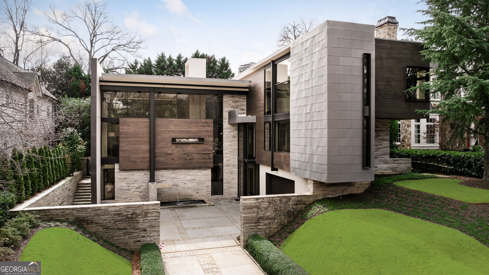 An amazing opportunity to own this award-winning modern masterpiece in Ansley Park. Widely recognized as one of Atlanta's most iconic modern residences, this home is a multiple design award-winning architectural property. Jim Choate, renowned architect, created this contemporary iconic modern residence and Robert Tretsch with Harrison Design is responsible for the renovation architectural work completed in 2022 adding additional square footage to the home including a private balcony/deck off the 2nd floor primary suite. This contemporary masterpiece has a striking material palette that includes western red cedar, zinc, IPE hardwood, Tennessee bluestone, and solid wenge flooring seamlessly blending modern aesthetics with natural elements. No expense was spared with custom Bontempi Italian kitchen, floor to ceiling fireplace, wine cellar, private first floor guest suite, primary bedroom suite with sitting area and spa bath with beautiful custom closet, two additional ensuite bedrooms upstairs, and bedroom/office suite on main floor. Outdoors provides a luxurious retreat with heated saltwater pool, half bath, and an outdoor kitchen. Perfectly positioned in Ansley Park, this extraordinary home offers walkability to some of Atlanta's finest restaurants and cultural attractions. Close access to Piedmont Park, High Museum of Art, Colony Square, Atlantic Station, and renowned Ansley Golf Club. Easy access to I-85 and I-75. A rare opportunity to own an award-winning residence that sets the standard for unique modern design in one of the most desirable neighborhoods.