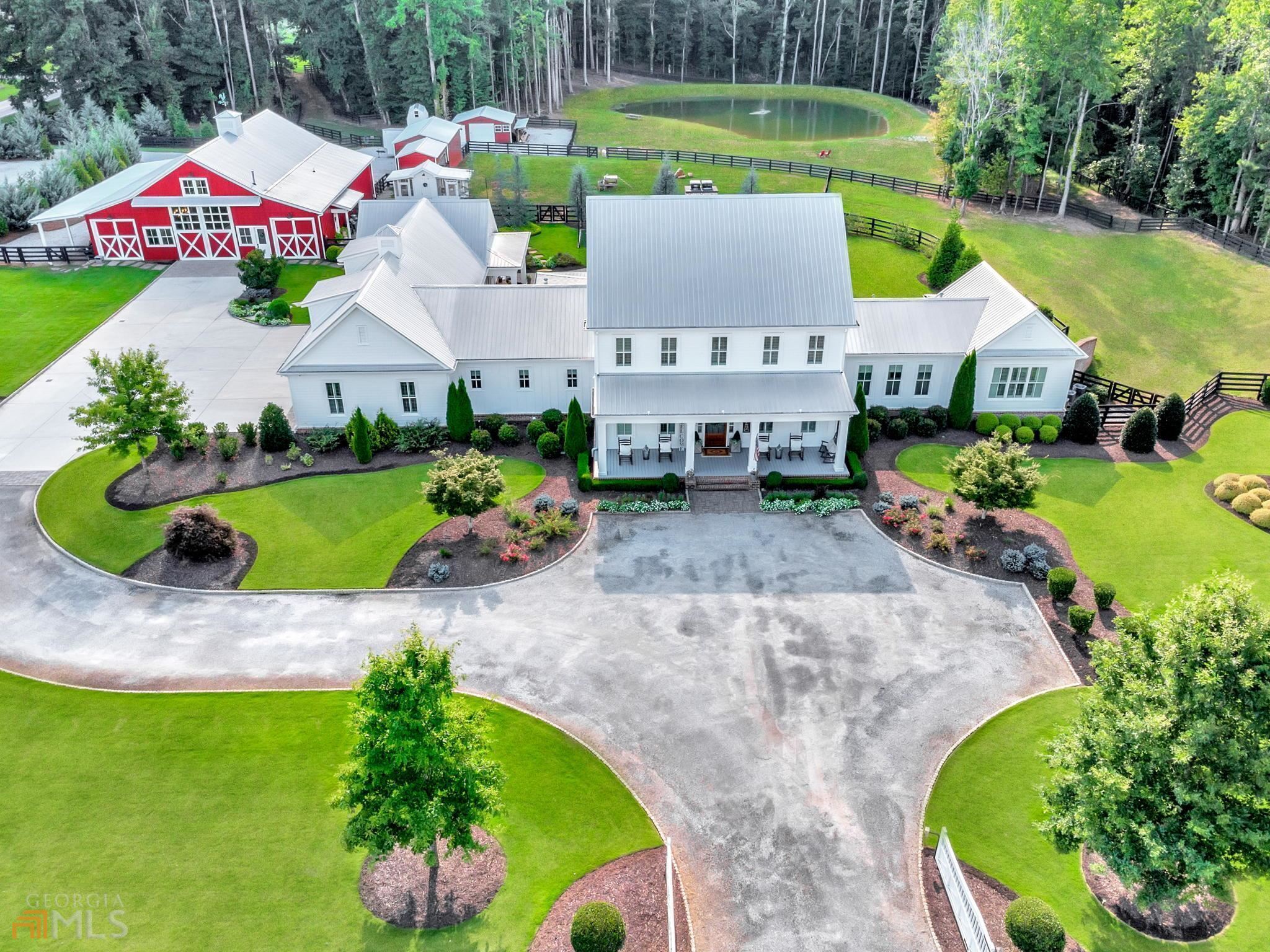 Exquisite Smith & Kennedy custom built, and gated, modern farmhouse perfectly situated on 6.15 flat acres with beautiful landscaping, a pond, and completely fenced in black four rail. Interior features include an open floor plan with master on main, an extraordinary kitchen with a chiseled edge quartz island and top of the line appliances overlooking the large family room. Additionally, a large pantry, mud room, a utility room with laundry and wash station, and a craft room/nursery. The impressive master bath features a large steam shower, sauna, garden tub, and a massive closet with laundry station. Upstairs there are 2 large bedrooms, each with their own bath, and a game/bonus room. The finished basement features a library, theatre/music room, exercise room, a full bathroom and additional bedroom with private entrance, plus storage space. There is also a guest suite off of the four-car garage that doubles as a pool house. Exterior features include a covered outdoor dining and living area with fireplace overlooking the beautiful pool, spa, and vast landscape with room for all of your animals. Now we move on to the 3360 sq ft barn that features rustic touches, a kitchen, a full bathroom, a well-appointed office, mechanical shop, and plenty of space to host events or store your toys. This is an incredible estate property with endless possibilities. Do not miss your opportunity.