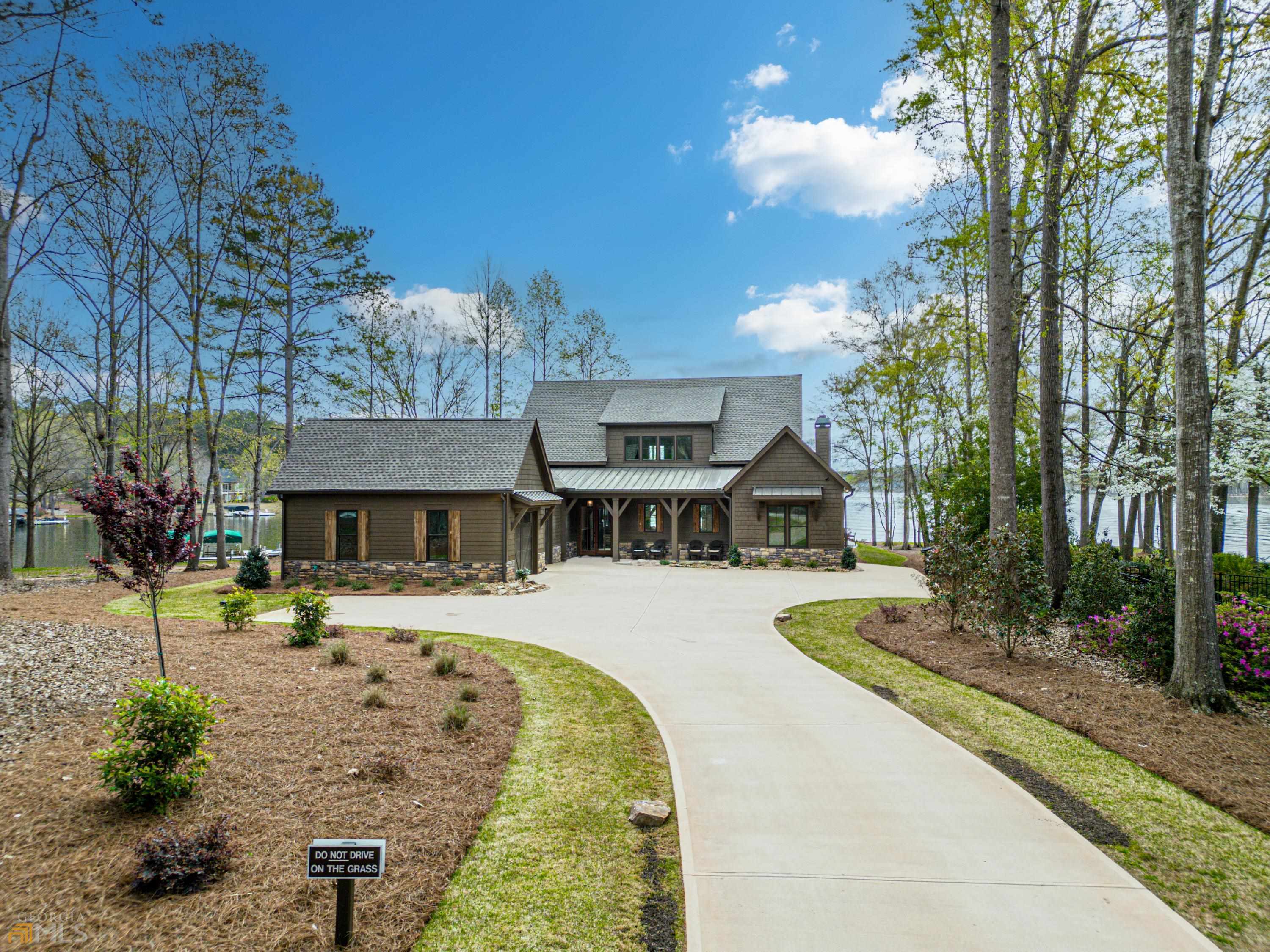 LAKEFRONT VIEW FROM POINT LOT ON LAKE OCONEE! Excellent location in Phoenix Lake subdivision just a few miles from Publix. No detail was overlooked in the design of this newly constructed in 2021 home. Highlights include: an open floor plan, large chefs' kitchen with upgraded appliances and walk in pantry, stone fireplaces in both the living room and screened in rear porch, master on the main level with vaulted ceiling and spectacular views and a custom safe room. The main level also features a guest bedroom with private bathroom. The second level includes two additional bedrooms with private bathrooms and a bunk room. The expansive rear porch overlooks the outdoor kitchen, custom spa, pool and fire pit area. The beautifully landscaped yard leads to a max dock and incredible views of the lake right across from Cuscowilla. Additionally, short term rentals are allowed in this neighborhood adding tremendous value to this one of kind property.