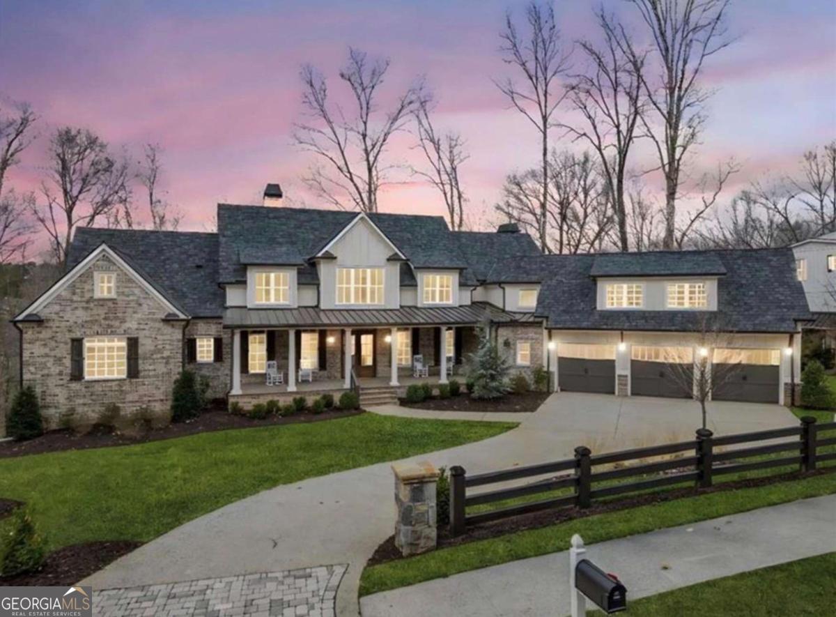 Introducing 310 Timberview Trail, a stunning, newly constructed custom estate nestled within the prestigious Liberty Grove enclave of Milton's coveted Blue Valley. This exclusive, gated community offers a serene environment with lush green spaces, remarkable amenities, and the added benefit of Cherokee County's lower property taxes. Crafted in 2023, this exceptional home features a highly sought-after layout with the primary suite conveniently located on the main level. The home also boasts a spacious laundry and mudroom, an openconcept dining area, an exquisite chef's kitchen, a private office, and a charming keeping room-all designed to seamlessly blend indoor and outdoor living, with direct access to the expansive covered patio. Set against a backdrop of unparalleled privacy, the beautifully landscaped lot is complete with a pool, hot tub, and multiple outdoor entertaining areas. Inside, natural light pours into the home through soaring ceilings, accentuating the open-concept design. The chef's kitchen is a masterpiece, featuring quartz countertops, a generous island, and a premium suite of appliances. A vaulted keeping room with a cozy fireplace offers stunning views of the private backyard, providing an ideal retreat within the home. Exquisite custom woodwork throughout the space elevates the property to a new level of elegance. The main floor also includes an oversized laundry room, with a secondary laundry space located upstairs. The second level hosts four luxurious ensuite bedrooms, each with spacious walk-in closets, along with an additional loft area for added flexibility. The fully finished terrace level is an entertainer's dream, complete with a state-of-the-art theatre room with a 12-foot screen, a fitness center, a recreation room with its own fireplace, and a full bathroom with both a shower and sauna. This level provides direct access to the heated pool and spa, which is perfect for entertaining guests. The outdoor space is wired for an impressive sound system, further enhancing the atmosphere. Special features throughout the home include a 17 SEER HVAC system, tankless water heaters, 50-year architectural shingles, spray foam insulation for optimal energy efficiency, and low-voltage wiring throughout with home automation capabilities and centralized lighting controlled via wireless internet repeaters. The pool area is ready for enjoyment, with a stunning custom railing and fire bowls that provide a magical ambiance as the sun sets.