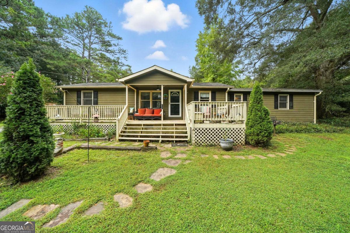 MOTIVATED SELLER! Discover the best of both worlds with this charming 3-bedroom, 2-bath ranch on a full acre in the heart of Woodstock. Tucked away on a private gravel drive, this home offers a peaceful, private retreat while keeping you close to all the shopping, dining, and energy of downtown. Step inside to find a spacious layout designed for both comfort and convenience. The living room features a cozy wood-burning fireplace, complemented by luxury vinyl flooring. The large kitchen makes cooking and entertaining a breeze, while a separate dining room and office area give you flexibility for everyday living. Beautiful barn doors, a dedicated computer nook, and thoughtful touches throughout add both style and function. The primary suite includes a walk-in closet and a spa-like bath with a wheelchair-accessible tub/shower combo featuring jacuzzi jets and aromatherapy. Wide, open spaces throughout the home make it welcoming and easy to navigate. Outside, the level yard provides ample space for gatherings, gardening, or simply enjoying the privacy of your land. A pole barn and outbuilding/workshop give you endless options for storage, hobbies, or projects. With plenty of parking, wheelchair accessibility, and a location that feels private yet central, this property is a rare find in bustling Woodstock.
