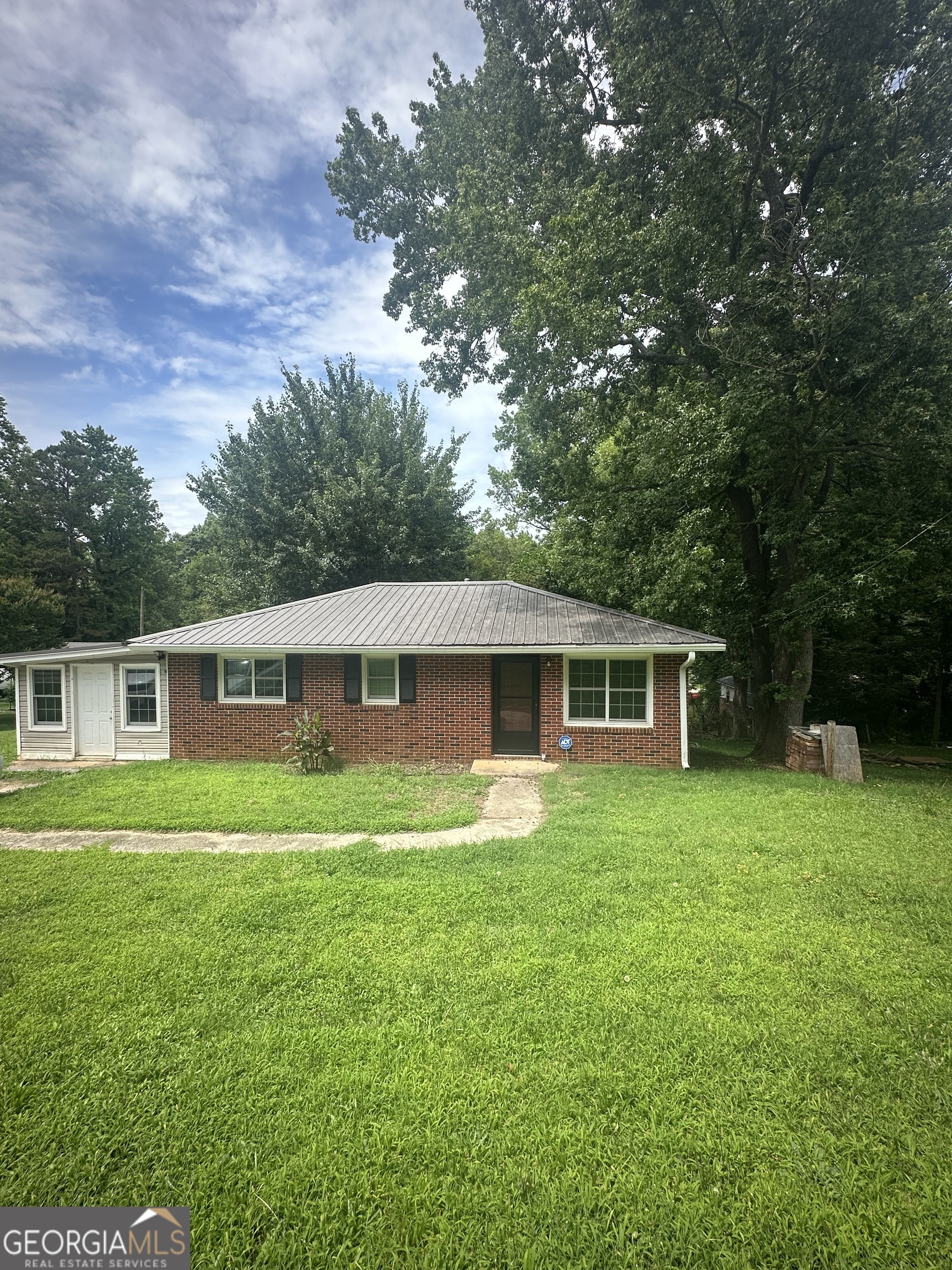 Adorable Brick Home in the City Limits of Royston! This 2 bedroom, 1.5 bath charmer has plenty of potential and a whole lot of character! Located right in town, it's perfect for first-time buyers, folks looking to downsize, or anyone wanting a solid investment property. You'll love the original hardwood floors in the bedrooms and the brand new flooring just installed in the living area. The living and kitchen spaces are open and inviting-perfect for easy living and visiting with family or friends. The carport has been enclosed, giving you a great space for a possible 3rd bedroom, office, or bonus room-whatever suits your needs! Other features include a newer HVAC unit, a metal roof, and a cozy yard that's just the right size for enjoying the outdoors without too much upkeep. Affordable, adorable, and move-in ready-this sweet little brick home is just waiting on you!