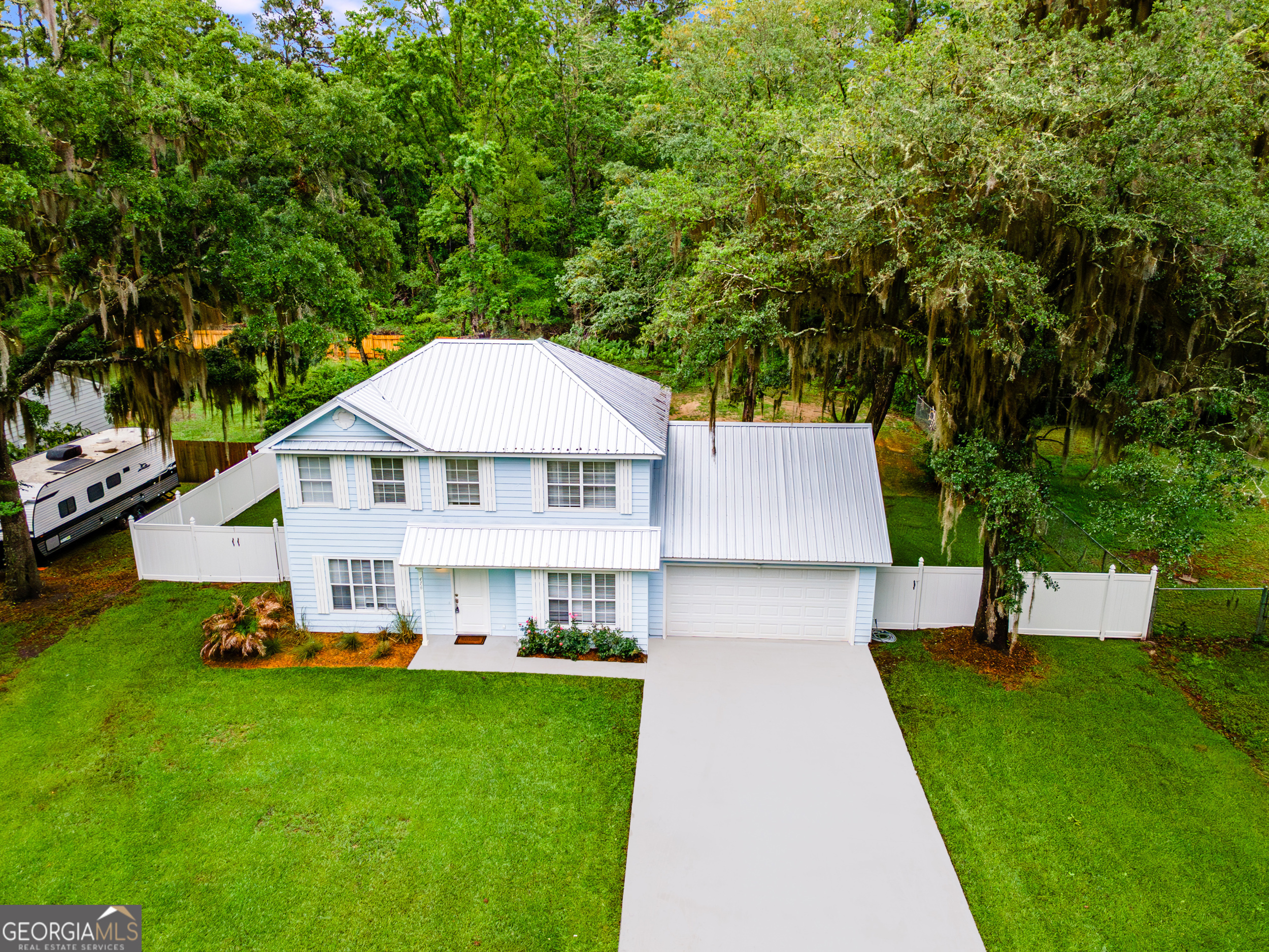 Renovated 3-bedroom, 2.5-bath home on approximately half an acre, surrounded by moss-draped oaks in a quiet Harrietts Bluff neighborhood-just 15 minutes to NSB Kings Bay. Inside, you'll find new LVP flooring throughout the main level and owner's suite, with new carpet in the two upstairs guest bedrooms. The kitchen features chevron-patterned butcher block countertops, a movable island, stainless steel appliances, and cabinets painted in a warm woodsy green. The custom walk-in pantry includes open stained wood shelving-attractive enough to leave the doors open. The dining room is just off the kitchen, along with a breakfast nook that includes a bay window overlooking the backyard. A renovated half bath on the main floor adds convenience for guests. The living area has new sliding glass doors that lead to a spacious back deck and fenced yard-great for outdoor entertaining. Upstairs, the owner's suite features a tray ceiling, walk-in closet, and a renovated bath with double vanity, a tiled shower, slipper tub, and wood-look tile floors. The guest bath also has wood-look tile and a unique tiled shower. Additional features include crown molding throughout, a two-car garage with storage cabinets and laundry hookups, a new tankless water heater, and new HVAC system. The new metal roof, newly poured concrete driveway and freshly sealed garage floors add to the value. Located in Flood Zone X, no flood insurance is required. There are no city taxes, and you're just a few miles to the public deep water boat ramp at Harrietts Bluff and less than 10 minutes to Kingsland amenities, restaurants, grocery, shopping and Chick-fil-A. This home blends comfort, convenience, and style with practical upgrades already in place.