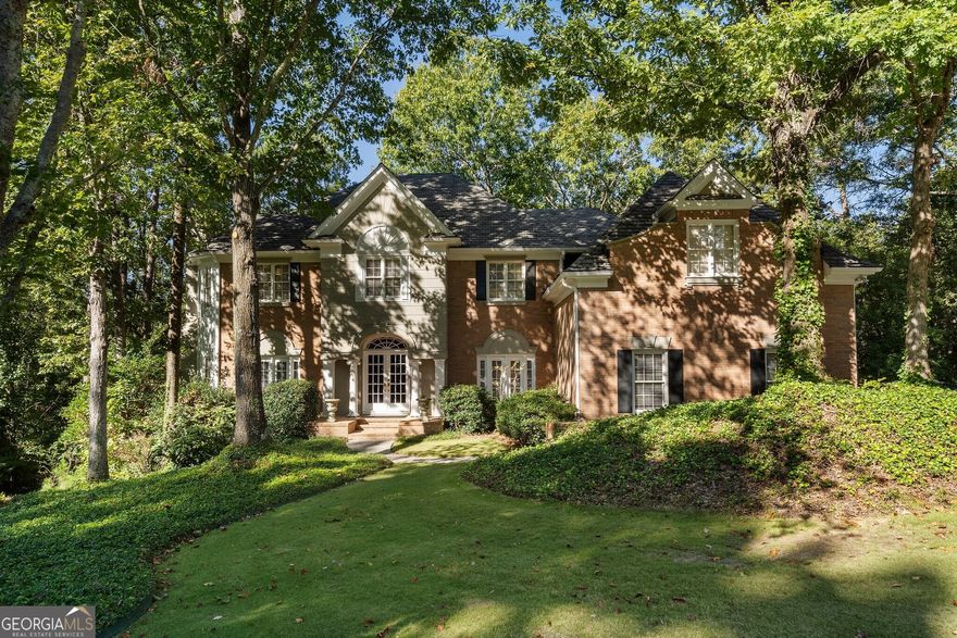 This stunning home, located at the end of a serene cul-de-sac in the Nesbit Lake Community, offers privacy and curb appeal. As you enter through the charming French doors, you're immediately drawn in by the impressive stonework in the entryway and elegant crown moldings. To your right from the foyer, the formal dining room is perfect for hosting dinner parties and also offers convenient access to the kitchen. Directly across the foyer is the formal living room, featuring a striking mantel and cozy fireplace. A private service bar bridges the living room and the den, making it an ideal setup for entertaining guests. The den exudes warmth, highlighted by an inviting fireplace and two sets of French doors that lead out to the back patio, where breathtaking views of the lake await. An informal dining area that can be used as a breakfast nook seamlessly transitions into the chef's kitchen. This kitchen features; a large island, high-end stainless steel appliances, tons of counter space, and a beverage fridge.  For added convenience, the laundry room is located on the main floor. Ascending the grand staircase, you'll notice the meticulous details, including built-in display spaces lining the walls. At the top of the stairs, you'll find the oversized primary suite, with a spacious, fully remodeled bathroom and generous custom closets. The luxurious spa-like bath boasts a beautiful stone and tile shower, stone countertops, and a luxurious soaking tub. Down the hall, there's a library and office featuring a fireplace and elegant paneling, making it an ideal space for working from home. You'll also find three spacious guest bedrooms with en suite baths. The fully finished terrace level, complete with a full bath and kitchenette. This versatile space features an extra family room, a TV/game room, and another guest bedroom, alongside plenty of storage options. With direct access to the backyard, it's an ideal retreat. No detail has been overlooked in this remarkable home. Adding to the retreat-like feel, you'll find a dock perfect for fishing in the stocked lake. The community is vibrant, offering access to swimming and tennis, along with kayaking and fishing opportunities. Neighborhood amenities include a clubhouse, six tennis courts, a swimming pool, a splash park, a playground, sidewalks, pickleball courts, and two fire pits.