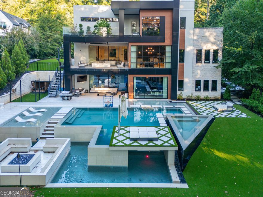 DEFINED LUXURY Awaits You in This Newly Built Contemporary Estate Home! Welcome to the pinnacle of modern luxury living in Sandy Springs just minutes to Buckhead, gated & offering exclusive luxury with ultimate privacy on every tree lined side. Designed for those who value quality, space, flow & the finest of finishes, this magazine worthy 4 Grand Bedroom, 6 (Spa Themed) Bathroom, 3 Car Garage Modern Contemporary Home includes an amazing finished terrace wonderland & breathtaking dream pool with waterfalls, spa, tanning ledges & floating walkways.  As you drive through the private tree lined gates, this home is perfectly situated far from the entry nestled upon a small hill to maximize privacy & perfectly showcase the beautiful contemporary clean lines of its stunning modern design. Prepare to be inspired & fall in love at first sight from the outside & in every room with this refreshing vision of clean lines combining a stone, stucco, metal & walnut themed exterior canvas with maximized floor to ceiling glass. From the dramatic walnut front pivot door with matching walnut accents & stunning exterior detailing, incredible steel floating stairs, soaring ceilings, extensive trim, tile & stone walls, Lutron lighting with automation color enhancements, linear diffusers, mega speakers, high ceilings with lit reverse treys, 8' doors, stunning stones & marbles throughout, designer tiles, custom floor to ceiling & floating cabinetry, refreshingly light wide plank hardwood flooring, multiple glass floor to ceiling pocket panels that open the walls to welcome you to the multiple inviting outdoor oasis, multiple decks & Zen zones, a gorgeous terrace waterfall edge bar, chilled glass wine room, top notch gym overlooking an incredible poolside paradise tree lined view, multiple offices, multiple flex & great rooms, walls of storybook floor to ceiling glass features to maximize natural light, floor to ceiling wall tiles, an incredible home theater, triple steel staircases, glass & metal railing, chef preferred appliances with expansive prep areas, double waterfall kitchen islands & hidden pantry, exquisite decorative lighting, gorgeous custom closet built-ins, hidden doors, paneled walls & so much more no detail was missed in this better than new modern luxury dream home. For those who appreciate distinctive design & finest quality, welcome to your new Atlanta resort styled, sports embraced, spa & entertainment themed home answering every want, wish & need. Featuring expansive bedroom suites with plentiful closets, breathtaking bathrooms, a culinary kitchen, multiple offices, an arcade area, filming room, finished terrace level, theater, multiple entertainment & breakfast bars, a game room, gym, multiple great rooms, a sauna, multiple Zen decks, an absolutely stunning infinity pool with waterfalls, floating walkways, tanning ledges, turfed golf practice areas, sports court, enhanced decking, a separate enclosed dog area & worry free turf rear lawn no wish or desire goes unanswered in this celebrity styled sports, recreation & wellness spa embraced home. Every convenience is at your fingertips with the best of automation, a backup generator, automated gates, quick & easy same day delivery zone, convenient access to top schools, 400, 285, 75, 85, Atlanta, Buckhead, Sandy Springs & Dunwoody, incredible entertainment & sports venues, plentiful parks & trails, foodie raved dining, fabulous shopping, minutes to St Joseph's, CHOA, Northside, Emory, GA Tech, yet sitting in picturesque gated privacy surrounded by mature trees where you can work, play, entertain & relax surrounded by tranquility. The pictures only begin to tell the story.  For those who appreciate distinctive design, finest quality & exceptional comforts, this thoughtfully designed architectural masterpiece offers unmatched elegance with dramatic designs that inspire & create the ultimate canvas for enjoying your best life. What are you waiting for?  Call for your private showing.
