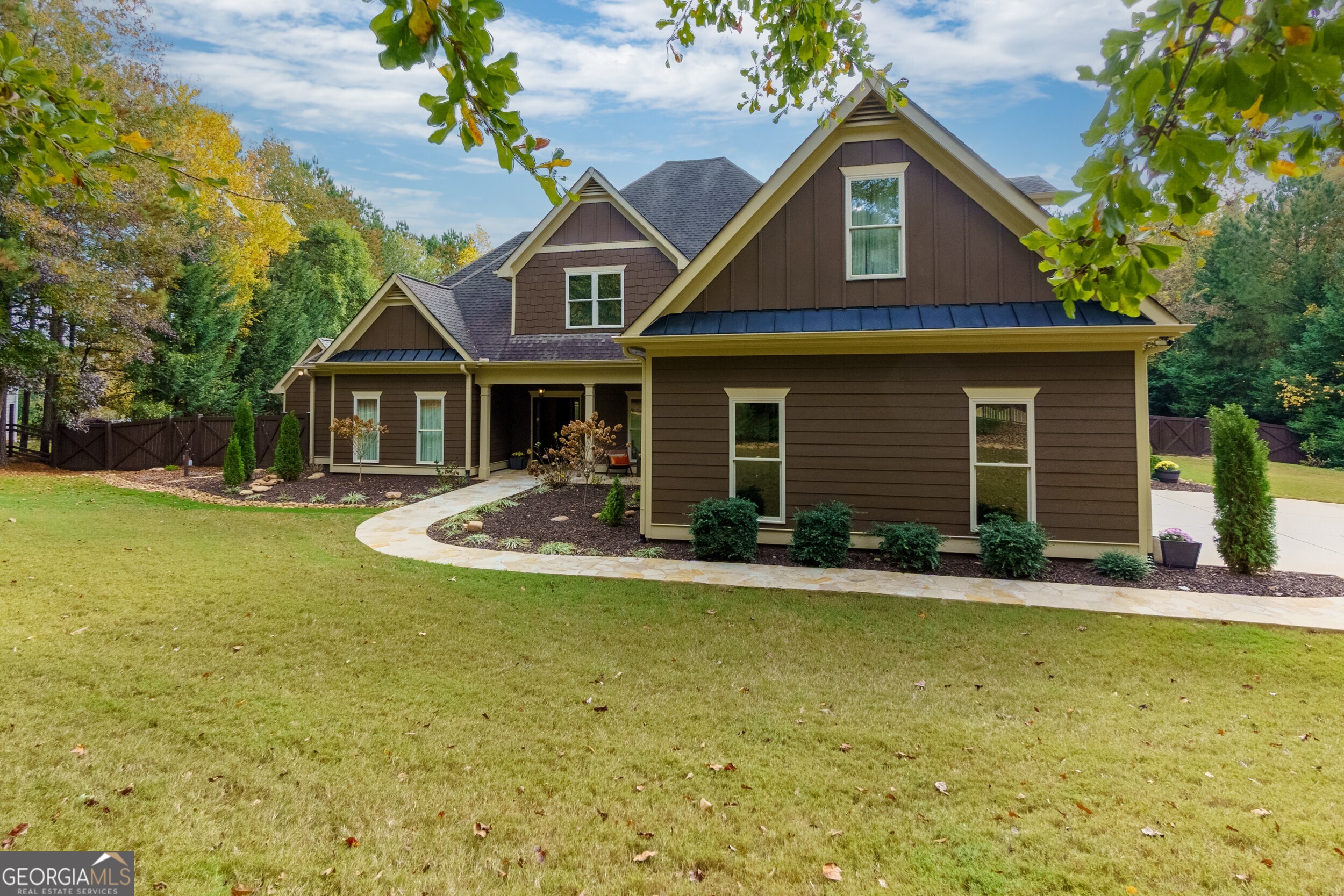 Tucked away at the end of a serene cul-de-sac on over an acre, this expanded Craftsman home offers timeless charm with a private setting. Designed for both style and function, the professionally curated interior features distinctive details and luxurious finishes, highlighted by Ralph Lauren metallic paint throughout. The main level boasts an open floor plan ideal for entertaining, anchored by a beam-framed dining area that exudes character. Adjacent, French doors lead to a sunroom ideal as a home office or gym, offering peaceful views. This floor also features two spacious bedrooms, including a luxurious primary suite with an ensuite bathroom, and two additional full bathrooms plus a convenient powder room. The open-concept kitchen is equipped with premium Jenn-Air appliances, full-wall cabinetry, and a walk-in pantry featuring four electrical outlets and a cleverly concealed space for small appliances. A state-of-the-art water purification system ensures pristine water quality. Upstairs, two additional bedrooms, each with its own private bathroom, provide an inviting retreat for guests. Additional highlights include a storm cellar or underground bunker, adding an extra layer of security and peace of mind. Outdoor living spaces abound, with a covered walk-out patio, a separate paved grilling area, and a newly constructed workshop fully wired for cable and internet. A spacious 3-car garage offers ample parking and storage, while a cutting-edge 4K security camera system is integrated directly into the home's TV wiring for added convenience. Offered fully furnished and move-in ready, this home is a true gem that's ready to be enjoyed.