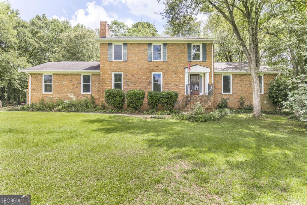 Looking for space!? Or instant equity!? We've got both here!! This beautiful, all brick, 2 story home sits on a private, 2.77 acre lot with fenced yard and rear patio, and 24'x34' three car detached garage/workshop! Inside, the home boasts 4 Br / 3.5 Ba and over 3,600 sqft. The large primary suite on the main has 11' ceilings and could double as a media room with adjacent private bar. Also on the main is a formal living room, large family room w/ brick fireplace, separate dining, and a roomy eat-in kitchen with an island bar, double oven, solid surface countertops, and plenty of cabinet and pantry space. The 2nd primary upstairs is massive and complete with its own brick fireplace! All this in a lovely lakefront community with access to a neighborhood boat ramp and dock, and easy access to shopping, dining, interstate and everything else you'll need. Priced to sell!!!