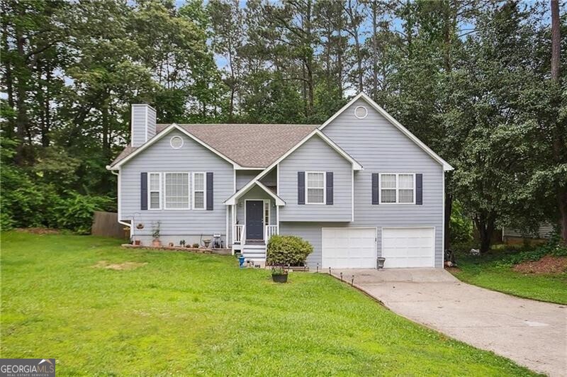 Welcome Home to Boone's Ridge! This wonderful home boasts 4 bedrooms, 3 full bathrooms plus additional bonus room on over a half acre private lot that backs to the Corp of Engineers Property with trails leading to Lake Allatoona! If you are looking for an inlaw or teen suite or AirBnB potential - this is the home for you! The 2 story split foyer welcomes you upstairs or downstairs featuring gorgeous wood flooring throughout the stairs and both levels of this home! Upstairs - raised ranch style with 3 bedrooms, 2 bathrooms, great room, kitchen and dining room all on main level. Downstairs - 4th large bedroom, full bathroom with barn door, bonus room with electric fireplace that stays and walk out of the French doors to the patio and beautiful split rail fenced in, private backyard. More details about the main level: a vaulted great room features a gorgeous brick fireplace and raised hearth with floor to ceiling picture windows, a large formal dining room with wall of windows and gorgeous chef's kitchen with ceramic tiled floors, granite countertops, stainless steel appliances including a 5 burner Dacor gas cook top, microwave, wall oven, side by side refrigerator and plenty of counter and cabinet space plus a pantry! From the kitchen, walk out to the large deck to view the private backyard! The oversized master suite boasts trey ceilings, a walk in closet, a beautiful updated master bath with a large soaking tub, separate shower with stunning tile work, double vanities with granite tops! The 2 additional main level bedrooms are good sized with ample closet space and share a beautiful updated bathroom with granite top vanity and a stunning tiled shower! Special feature of this home is the enormous 2+ car garage with garage door openers. This garage area is enormous - see details in pics.