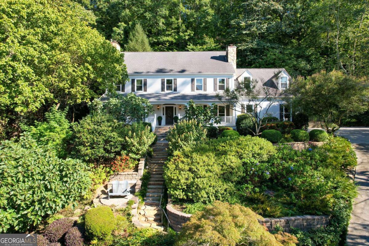 A true Sandy Springs oasis, this Southern charmer is nestled in the highly sought-after River Chase Swim & Tennis community. Situated on a quiet, level street, the home offers views of the Chattahoochee River and is surrounded by lush landscaping and the tranquil sounds of cascading water features. Seamlessly blending timeless architecture with thoughtful modern updates, this beautiful residence is a serene retreat just minutes from all that Sandy Springs has to offer. Enter from the inviting rocking-chair front porch and you're greeted by a gracious foyer that opens to a home designed for both comfortable living and elegant entertaining. The main level features a seamless flow, rich hardwoods, 9+ foot ceilings, custom millwork, and refined architectural details throughout. A formal living room with river views, a wet bar, and an elegant dining room that seats twelve flow, a sunlit den and a stylish half-bath. The chef's kitchen is a standout with newly updated countertops, two Decor ovens, custom cabinetry, and a bay-window breakfast nook. A large island with prep sink and breakfast bar makes the space as functional as it is beautiful. Convenient direct access from the two-car garage into the kitchen enhances everyday living. Upstairs, the spacious primary suite feels like a true retreat, featuring a spa-inspired bathroom with a rain head shower, side jets, dual vanities, and abundant natural light from a skylight and oversized window. Three additional bedrooms, including one with an ensuite bath, offer comfortable space for family or guests. A large bonus room with custom built-ins provides endless flexibility-perfect as a playroom, media space, home office or oversized guest suite. Outdoors, the home is a garden lover's dream. The Master Gardener-designed surroundings offer year-round blooms with camellias, hydrangeas, azaleas, Japanese maples, fig trees and more. A cascading waterfall adds tranquil sound and ambiance to the already serene setting. More than $100,000 in professional hardscaping and lighting further elevates living. The River Chase Club is also on Ferry Landing and is rich with amenities! Enjoy the clubhouse, pool with lifeguards and a swim team, tennis courts and ALTA team, basketball hoop, fire pits, and an outdoor kitchen-all located just steps from the river. With a cul-de-sac on one end and the Club amenities on the other, life on Ferry Landing offers the perfect balance of privacy and connection. Located minutes from top-rated public and private schools, with easy access to shopping, dining, and cultural attractions in Sandy Springs, Buckhead, Midtown, and Downtown Atlanta, the home has quick access to major highways, including I-285, I-75, and GA-400. Whether you're enjoying morning coffee with river views or entertaining guests, this is a rare opportunity to own a sanctuary that blends classic design, refined updates, and an unbeatable location!
