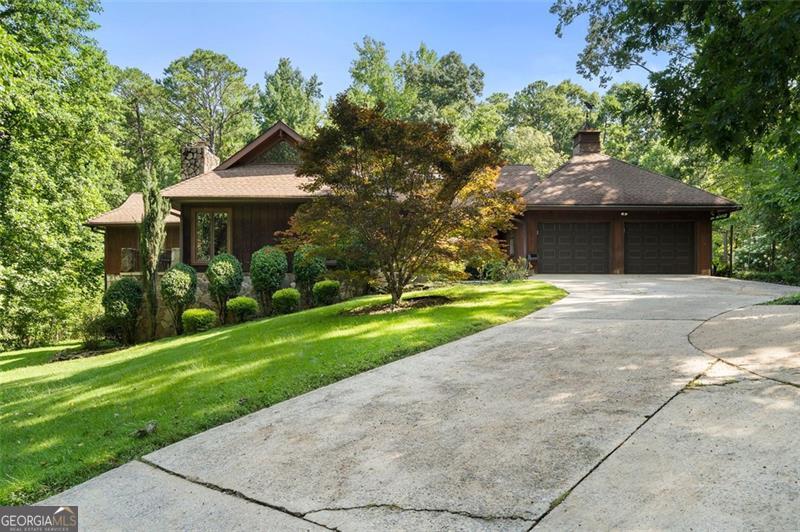 Discover your private sanctuary in Douglasville's best-kept secret, Valli-Hi Estates. This custom-built 4 bedroom and 4 bathroom traditional home provides 4,400 square feet of beautifully appointed living space. Step inside to a stunning great room featuring vaulted, beamed ceilings, oversized windows to let in the sunlight, rich hardwood floors, and one of two cozy fireplaces. Formal dining area flows into the open concept, cozy family room overlooking the gourmet kitchen with an abundance of storage with soft close drawers- centered around a spectacular 12-foot granite island and equipped with a professional gas cooktop, stainless steel appliances, a coffee bar, and a wine bar. The huge primary bedroom and spa-like en suite bath with double vanity granite counters, custom tiled shower, and separate granite surrounded soaking tub are conveniently located on the main floor. A second versatile bedroom and full bath on this level provides the perfect space for guests, a home office, or multi-generational living. Upstairs, discover two oversized bedrooms and a breathtaking, custom-tiled bathroom also with double vanity granite counters, stand alone soaking tub, and tiled shower. Venture down the unique spiral staircase to the finished daylight basement with yet another custom tiled bathroom with soaking tub. This bright, open space, with direct access to the grounds (and pool), is your blank canvas for a home gym, media room, or the ultimate poolside lounge. Your outdoor paradise awaits. Spend hot, sunny days lounging by the gorgeous in-ground pool, find tranquility in the stone courtyard with its classic fountain, relax on the balconies overlooking the grounds, or utilize the large workshop for your hobbies. This home seamlessly blends refined interior details with magnificent natural surroundings. Tucked away on FOUR secluded acres complete with blueberry bushes and two spring-fed creeks, this property offers serene country living while being just 25 miles from Hartsfield-Jackson Airport and 22 miles from downtown Atlanta.