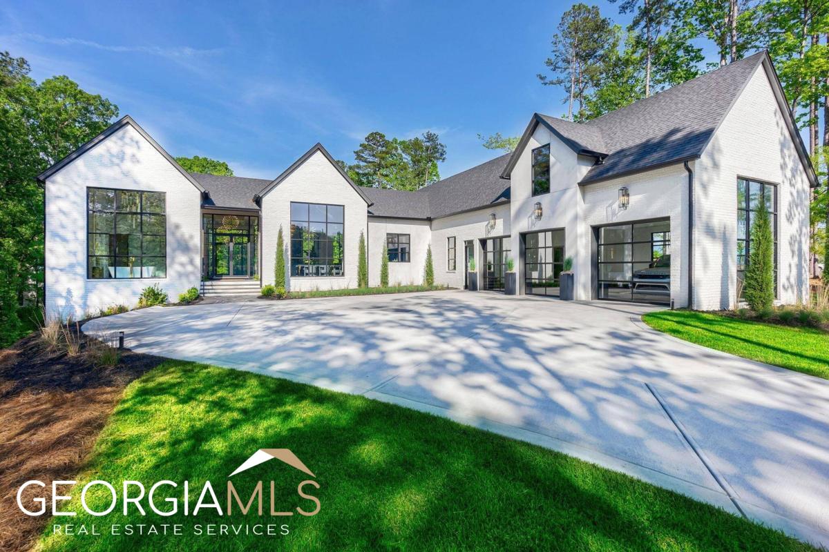 BRAND NEW STUNNING LAKE HOME OFFERING A BLEND OF MODERN DESIGN, TIMELESS ELEGANCE AND LUXURIOUS AMENITIES AT REYNOLDS LAKE OCONEE. This move-in ready, beautifully furnished lake access masterpiece features a transitional architecture and boasts over 5,000 sq ft, 5 beds/5 baths, pool, lake cove views plus an assigned boat slip.The impressive front & rear elevation with classic white brick set the tone for the grandeur within.Expansive floor-to-ceiling windows throughout flood the space with natural light,providing breathtaking views of the outdoors.Notable features of the home include modern glass garage doors,pebble-tec/saltwater pool w/autocover, outdoor kitchen, firepit patio area, upgraded landscape package. As you walk in, you will notice an open concept w/ grand spaces and soaring 22' ceiling heights. Only the finest, contemporary finishes adorn this new build; custom European-style flat panel cabinetry throughout, French white oak wide-plank hardwoods, linear electric fireplaces w/ large format tile the ceilings, chic lighting fixtures, glass staircase, marble & quartzite surfaces, etc. The open kitchen offers 14' tall cabinetry, oversized 13' kitchen island with mitered waterfall countertops, Monogram 36" fridge and freezer panels, Miele coffee maker, two Kitchen-Aid custom panel-hidden dishwashers, and ZLINE Autograph Edition 48" dual-fuel range, a separate pantry room with additional custom cabinetry and shelving. Dining room includes chevron floors and a showstopping custom 72 bottle glass wine wall. The primary and secondary suite (or office) are offered on the main level w/ shaft in place for future elevator. The primary suite is light & bright w/ floor-to-ceiling windows, offers a dressing room with cabinetry for additional storage, an oversized primary walk-in closet with island. Primary bath is spa-like w/ 18' ceilings, tile and marble throughout, floating vanities and a jaw-dropping chandelier over freestanding tub. Laundry room w/dog shower + washer/dryer. The terrace level offers additional 3 bedrooms/3 baths, including a second living area w/ floor-to-ceiling windows and ideal views of the pool, an entertainers bar with mitered waterfall island, and fitted with microwave drawer,/dishwasher/column wine fridge/bar sink. Outdoor living spaces are in abundance with over 1,551 sq.ft of porches, decks, patios. 1,824 in unfinished sq.ft. This home is perfectly situated within boating minutes to the Ritz Carlton. Membership available.