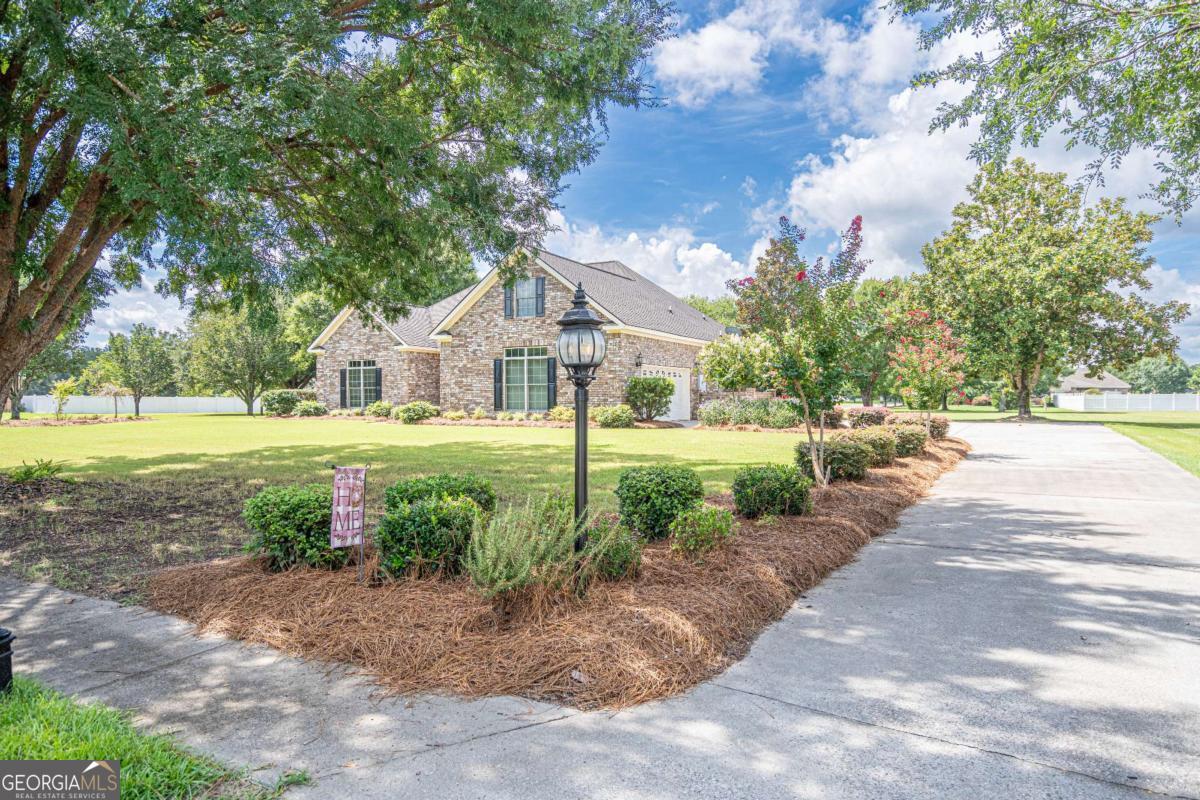 Former Mike Stewart Model Home in Honey Ridge Estates! Meticulously maintained, this all-brick 5 bedroom, 3.5 bath home sits on a beautiful corner lot just under an acre with mature trees and a wide-open backyard. The split floor plan features tall ceilings, recessed lighting, whole-home wired speakers, and wood flooring throughout the main living areas. Bedrooms have plush carpet that looks brand new, and the upstairs ensuite is perfect for guests or multi-generational living. The interior kitchen and separate outdoor kitchen offer versatility for everyday living and entertaining. Enjoy a central vacuum system, two 220-amp hookups for an electric car and generator, and a sprinkler system on a deep well. Once the neighborhood's model home, this property boasts premium upgrades and thoughtful details in every room. Located in sought-after Honey Ridge Estates, you'll enjoy community amenities and a welcoming neighborhood atmosphere. Claim your space-this one is move-in ready! Once the neighborhood's model home, this property showcases premium upgrades from top to bottom. Call this house a home today!
