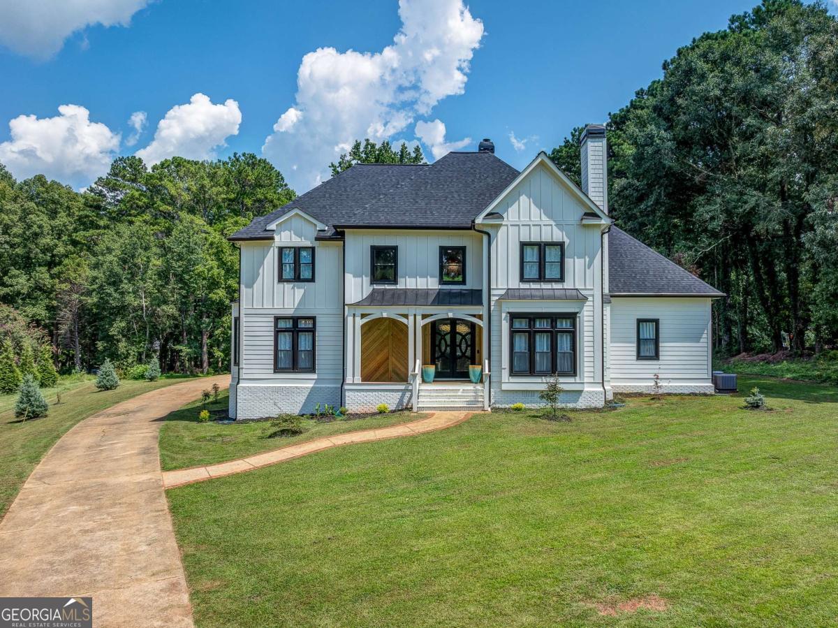 Welcome to your private oasis nestled on 2.6 acres of pristine land, where modern luxury meets everyday comfort. This stunning 4-bedroom, 3-bathroom estate has been fully renovated and reimagined with high-end finishes and thoughtful details throughout. From the moment you enter the two-story foyer and soaring living room, you'll be captivated by the elegance of the new modern lighting package, custom wrought iron railings, and the seamless flow of natural light. The gourmet kitchen boasts a 6-foot cascading natural stone island with custom backsplash, retractable bi-fold doors for indoor/outdoor living, and an open concept perfect for gatherings. The luxury owner's suite is a true retreat, featuring a beautiful fire place, a spa-inspired bathroom with a freestanding soaking tub, a three-head steam shower, bidet, a custom walk-in closet designed to impress, and a private screened in deck for relaxation on a calm morning or after a long work day. Step outside to a massive new deck with custom outdoor lighting, ideal for entertaining guests while overlooking your beautifully manicured lawn. Off the front porch you'll enjoy newly planted landscaping to include Japanese Maples, Weeping Willows, and Blue Spruce Pines. Car enthusiasts will love the 12-car detached garage (with new roof) in addition to the 2-car attached garage, providing ample space for collections, hobbies, or storage. Recent Upgrades Include: New roof on both main home & detached garage. New Exterior and Interior Paint All Newly renovated bathrooms (tile, tub, toilets, vanities) New carpet throughout. Four fireplaces with updated tile .New septic tanks & foundational support system by AquaGuard. New sump pump & drainage system Replaced HVAC system Bluetooth bathroom vents ,New exterior siding, doors, and added exterior lighting, Interior tube slide for fun & functionality This home truly has it all. Luxury, land, and lifestyle.