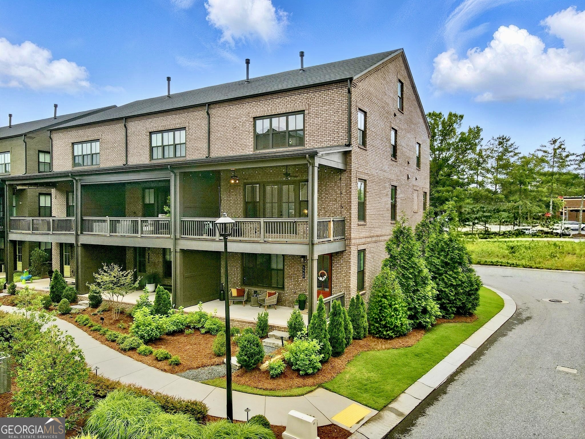Modern 3-Story Corner Townhome in the Heart of Halcyon - Alpharetta, GA Welcome home to this stunning 4-bedroom, 3.5-bathroom corner townhome in the highly desirable Halcyon community - where style, comfort, and location come together beautifully. Built in 2021 and move-in ready, this home features hardwood floors on all levels (no carpet!), a 2-car garage, and elevated finishes across three spacious levels. Step onto the inviting covered front porch - the perfect spot to enjoy your morning coffee or unwind in the afternoon - and enter into a bright, open foyer on the lower level. This floor includes a guest bedroom with views of the porch, a full bathroom, a large storage closet, and a convenient built-in bench near the door to the garage. There's also a second entrance at the back of the home next to the garage for added convenience. The main level is designed for everyday comfort and entertaining. The gourmet kitchen boasts quartz countertops, a large island with sink and seating, a gas cooktop with vent hood, built-in oven and microwave, 3-door stainless steel fridge, tile backsplash, and a large walk-in pantry. Across the kitchen, a bar nook with wine cooler and stone counters offers a stylish touch. The dining area is located near a tucked-away desk nook, ideal for a home office setup. The cozy living room, complete with a gas fireplace, opens up to a private deck, perfect for indoor-outdoor living. Upstairs, you'll find the owner's suite featuring tray ceilings, a spa-inspired bathroom with double vanities, a glass-enclosed walk-in shower, a private water closet, and a generous walk-in closet with built-ins and natural light. Two additional guest bedrooms share a full bathroom with a stone countertops vanity and shower/tub combo. A laundry room with washer and dryer and a large linen closet provide extra convenience. As an added bonus, this home has elevator potential - three oversized closets located on each level (including the pantry on the main floor) are perfectly aligned to be converted into an elevator shaft in the future, if desired. The Halcyon community offers the ultimate live-work-play lifestyle, with walkable access to top-tier shopping, dining, and entertainment - including Trader Joe's just down the street! Community amenities include a covered gazebo for events, green space, a sparkling pool, and a cozy firepit area perfect for socializing year-round. Unbeatable Location: Just off GA-400, you'll enjoy easy highway access for a quick commute to Atlanta, top-rated schools, and everything North Fulton has to offer.Location. Comfort. Community. This townhome checks all the boxes - schedule your tour today and make it yours!