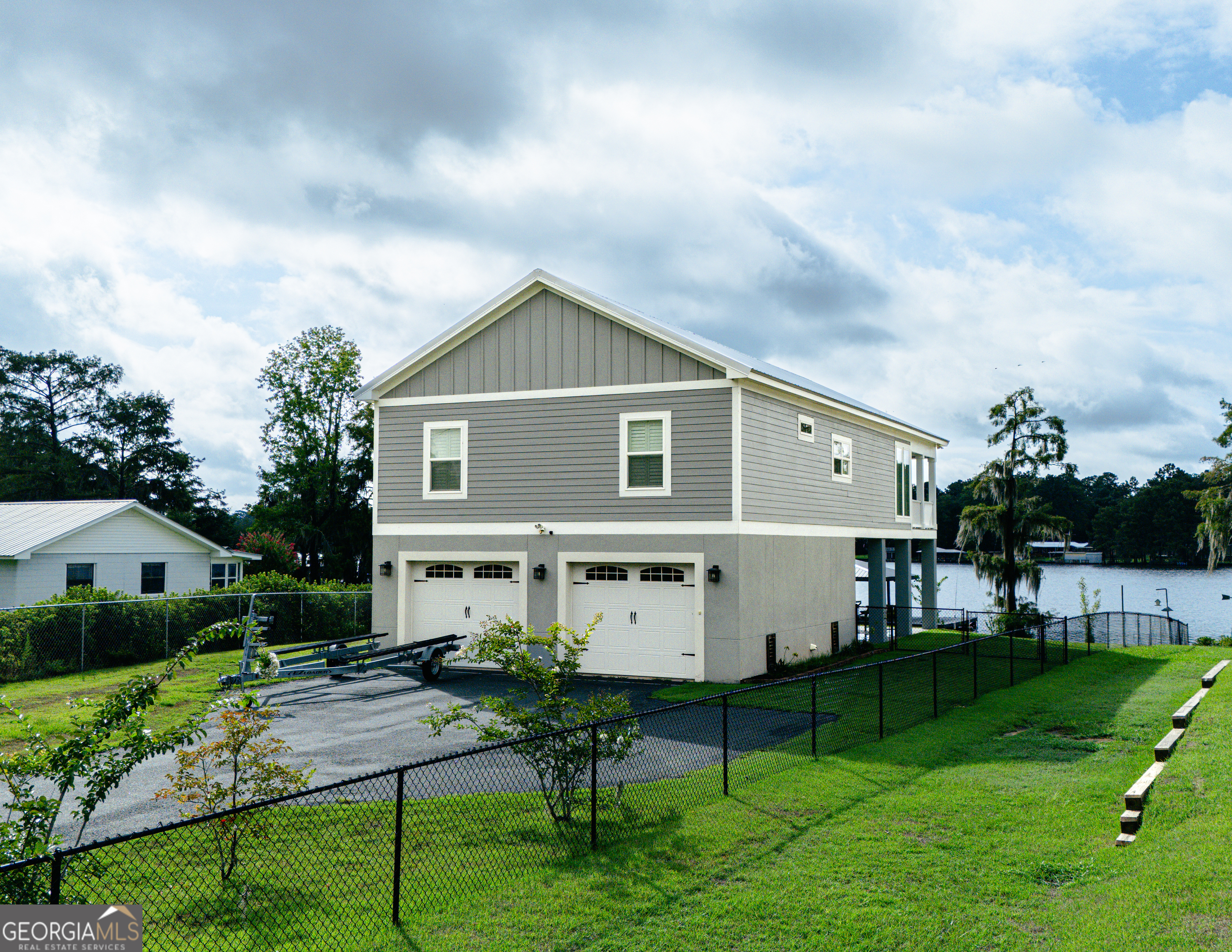 Lake Blackshear custom-built home featuring breathtaking views and serene lakefront living. A private elevator takes you to the main living area, where natural light fills the space and enhances the stunning vistas. Three bedroom, 2 bath home with private guest bathrooms, main suite with custom bathroom, double glass doors leading to a private covered deck. Granite countertops, private dock and boat lift, and more waiting for the perfect water lover. Experience luxury, privacy and stunning lakefront living!