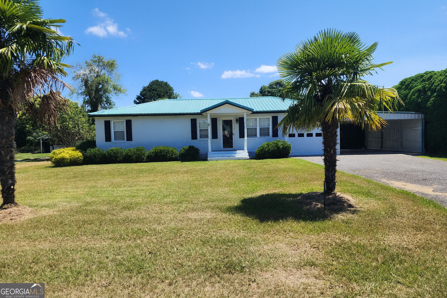Immaculately Maintained Home on Spacious Lot - Just Outside Cochran City Limits! Discover peaceful living in this beautifully kept 3-bedroom, 1-bath home situated on a generous 0.42-acre lot. With over 1,700 sq ft of well-designed living space, this home offers solid surface countertops, a central kitchen island, farmhouse sink and a formal sitting room ideal for entertaining. Enjoy abundant natural light throughout, especially in the large sunroom that opens via sliding doors to an expansive screened-in porch-perfect for relaxing or hosting guests. The home features an exterior ramp for easy access. Outside, you'll find a beautifully landscaped and fenced backyard, surrounded by privacy hedges, creating your own private oasis. Additional features include a garage with door opener, carport, and plenty of storage. Located just beyond city limits,enjoy peaceful surroundings with all the conveniences of town nearby. Don't miss this rare gem-move-in ready!