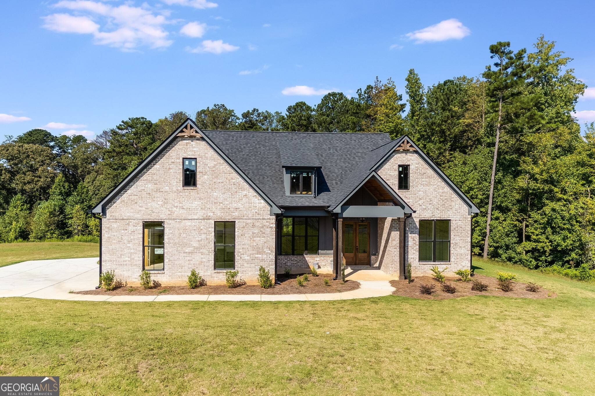 Welcome home to this stunning stepless ranch farmhouse, perfectly situated on 1.37 acres in a peaceful country setting while still being just minutes from grocery stores and dining options. This thoughtfully designed home features LVP flooring throughout, with tile in the bathrooms and laundry room for added durability and style. The open concept living room, kitchen, and dining area creates the ideal space for entertaining or simply enjoying family time. The living room is highlighted by an electric fireplace for cozy evenings. The master suite is a true retreat, complete with a huge walk-in closet, and a luxurious master bath featuring a double vanity, tile shower with frameless glass door, and a relaxing soaking tub. Step outside to the covered back patio, where you'll find a wood-burning fireplace, perfect for gatherings on cool evenings or simply enjoying the tranquility of your property. Don't miss the opportunity to own this beautiful new construction home that combines modern farmhouse charm with convenience and comfort.