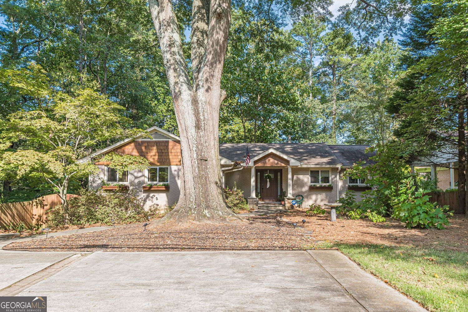 Welcome to this beautifully updated ranch style home nestled in the heart of Druid Hills, one of Atlanta's most sought after neighborhoods, just minutes from Emory University and Emory Campus Hospital. This home offers exceptional privacy in a serene setting while being close to everything and walkable to Emory Village. A wall of windows stretches across the back of the home, flooding the interior with natural light and offering peaceful views of lush surroundings. The spacious open concept living and dining room is perfect for entertaining or relaxing, with a seamless flow and warm, inviting atmosphere. The cheerful, white galley kitchen is bathed in sunlight and designed for both functionality and style. The generous primary bedroom easily accommodates a king-sized bed and offers a quiet, spa-like retreat. Two additional bedrooms provide flexibility for family, guests, or a home office. Ample off-street parking includes a convenient front parking pad and a rear-entry, 2-car, drive-under garage. This turnkey home blends classic charm with modern updates in an unbeatable location. Don't miss your chance to live in one of Atlanta's most beloved neighborhoods!