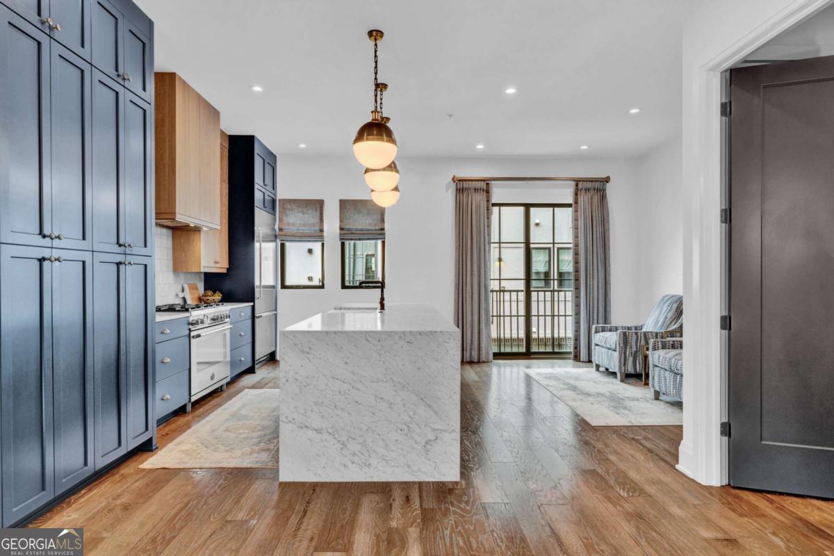 Live the Beltline life to its fullest in this 4 bed, 4.5 bath end unit townhome in one of Atlanta's most desirable neighborhoods, Inman Park. This townhome at Emerson on Krog has one of the most private locations in the community, tucked away from main roads giving you the the perfect blend of privacy and walkability. Featuring four levels of refined living with a private elevator, two-car garage, and designer finishes throughout, this home is both elegant and effortless. The main level features a marble waterfall island, Bertazzoni appliances, custom cabinetry, and a cozy sitting room off the kitchen, along with a sun-filled dining room, stylish half bath, and living room with soaring ceilings. A Francois stone fireplace and black-trimmed windows anchor the living room and wide-plank oak floors are throughout the entire home. Upstairs, the primary suite offers a walk-in closet with custom shelving, a sitting area, and a spa-like bath, while another en-suite bedroom and a custom-shelved laundry room complete the floor. The top level, complete with a full bath, offers a versatile space ideal for a media or game room, home office, or fourth bedroom. The true showstopper is the pair of rooftop decks with rich IPE decking, perfect for year-round entertaining. One is fully equipped with a built-in grill, fridge, and sink, while the other offers sweeping city views-and just above, a rooftop perch delivers panoramic vistas and unforgettable sunsets. With low HOA dues and steps to the Beltline, Krog Street Market, and Inman Park dining and shopping, this is luxury living at its best. Welcome Home!