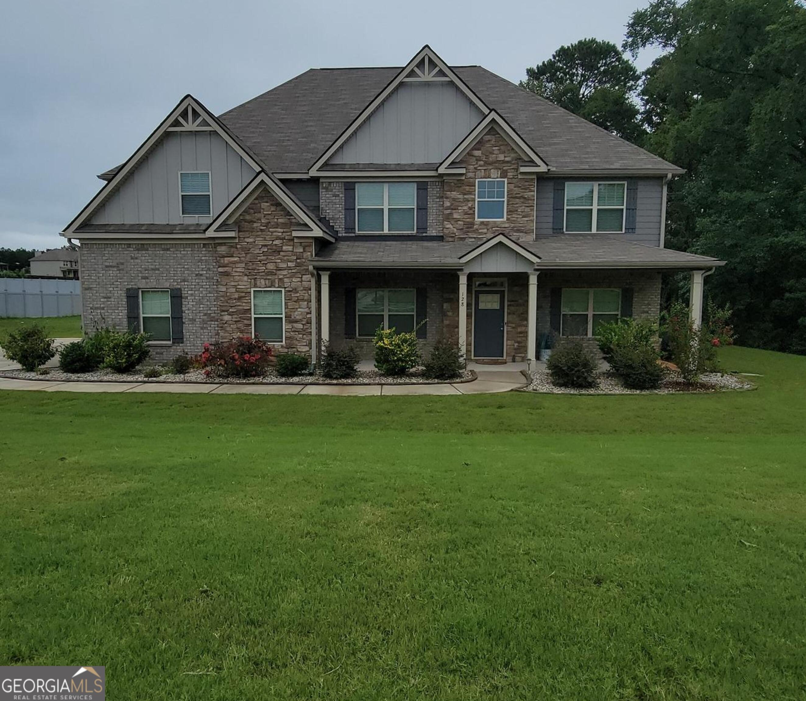 Live beautifully behind the gates of Laurel Park. From the moment you arrive, this home welcomes you with timeless brick-and-stone curb appeal, an inviting front porch, and a wide side-entry garage tucked on nearly 3/4 of an acre. Inside, warm hardwoods flow throughout a bright and open main level ideal for both everyday living and hosting guests. The kitchen is a true gathering space, featuring granite countertops, a walk-in pantry, and views into the oversized living room. Need space for visitors? A full guest suite on the main offers comfort and privacy. Upstairs, the primary suite is a personal retreat with a spa-inspired bath and an expansive walk-in closet. Step outside to a spacious backyard with an irrigation system-perfect for quiet mornings, lively weekends, or adding a future pool. Enjoy smart-home features, room to grow, and a lifestyle of ease just minutes from shopping, and dining.