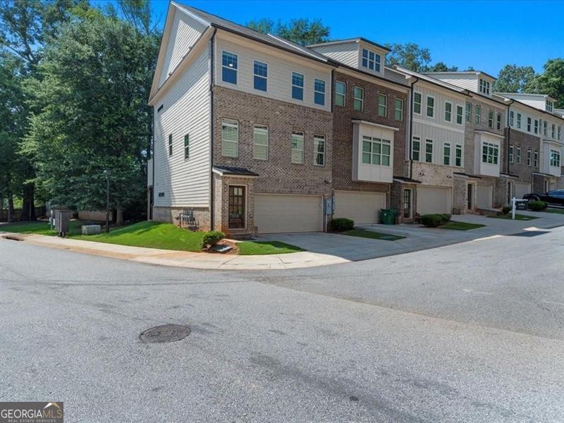 Welcome to your beautifully upgraded townhome, ideally located near entertainment, shopping, dining, Emory University, the CDC, Dekalb Medical, Marta, and Downtown plus a new Publix just around the corner! Step inside to find stunning hardwood floors throughout and a chef's kitchen designed to impress, complete with stylish pendant lighting. The open main level features soaring 10-foot ceilings and large windows that flood the space with natural light, creating a warm and inviting atmosphere. As an end unit, this townhome offers a spacious dining and kitchen area that seamlessly flows into the family room, which leads out to a full rear deck surrounded by lush trees-perfect for relaxing or entertaining. With three levels of thoughtfully designed living space, you'll enjoy a generously sized suite on the Terrace level, along with a convenient 2-car garage that includes ample dedicated storage. Located in a small, gated community built by Water's Edge Group in 2019, this townhome truly has it all! Don't miss your chance to experience comfortable living in this vibrant and well-connected neighborhood.