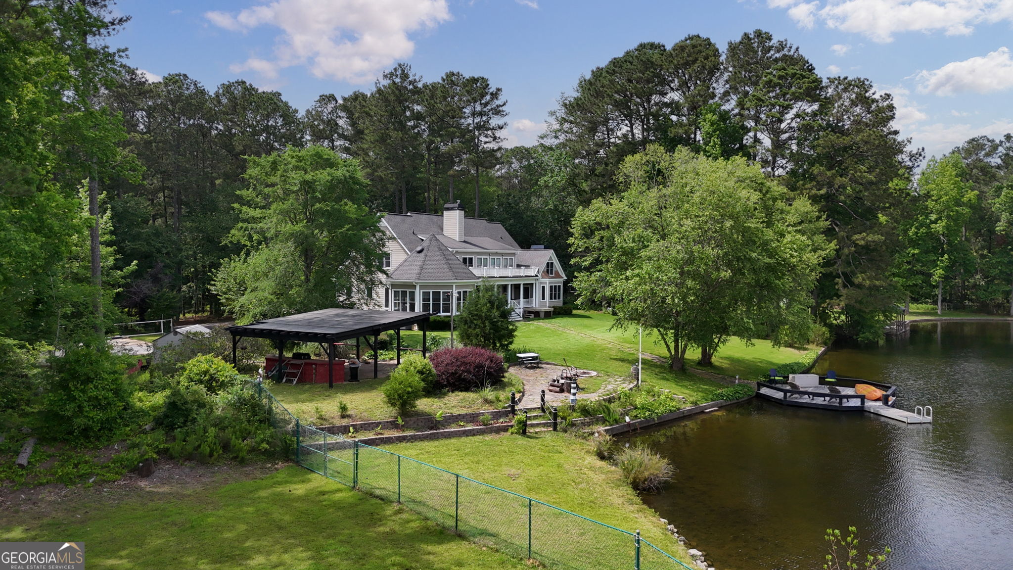 Private Lakefront Retreat with Stunning Views Welcome to your dream home on a serene private lake, offering over 3 acres of natural beauty, privacy, and outdoor enjoyment. This unique property boasts a master suite on the main level with its own fireplace and breathtaking lake views. Step into the octagon sunroom, perfect for soaking in the scenery year-round, or unwind in the hot tub after a day of fishing or kayaking right from your private dock. The wood-burning stove adds rustic charm, while solar energy provides modern efficiency. Upstairs, you'll find two spacious bedrooms, each with a private full bath and access to a cozy loft area-ideal for guests or family. The separate dining room and well-appointed living spaces make entertaining effortless. Outdoor lovers will enjoy the lush garden, sand volleyball court, and expansive yard with room to roam, play, or simply relax in nature. Additional features include a partial drive-under basement for storage or workshop space, RV Hookups and a location just minutes from Emory Oxford, Covington City Square with shops and eateries as well as the Cinelease Studios movie production company. All this combines to create convenience with peaceful, private living. This is more than a home-it's a lifestyle. Explanation of the Solar power at this home: It was purchased and installed at $30,000 for a system of 27 panels with an inverter and it has been hooked to the grid. All permits were obtained to provide power to Covington gas and electric. Resident uses whatever power is produced and extra is sent back to the grid. There is a special meter and app to keep track of the usage. Owner is paid for anything sent to the grid. For example, in the summer, when production is the highest, bills are credited for electricity not used in the daytime. An electric bill in summer running 4 a/c units to cool a 4000+ sq ft house in the past would have been $500-700./month. With solar, the bill is usually less than $100 for gas/electric. There are maintenance fees on all bills.