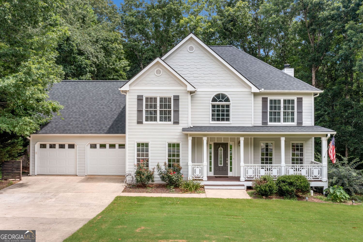 Welcome to this charming home nestled on a generous 0.8-acre wooded lot surrounded by greenspace. You'll appreciate the quiet privacy and natural beauty the moment you arrive. Kitchen-level parking makes life easier, and the covered country front porch is the perfect spot for morning coffee or relaxing at day's end. Step inside to find stunning hardwood floors on the main level and a dramatic two-story foyer that floods the space with light. The open floorplan connects the living areas with ease. The kitchen features a bright eat-in space, breakfast bar, and mobile island for flexible prep or serving. A formal dining room nearby adds an elegant space for gatherings. Upstairs, the spacious primary suite offers a true retreat with a large walk-in closet. You'll also find a large upstairs laundry room with a utility sink for added convenience. All secondary bedrooms are spacious. There's also a standout guest or in-law suite. It rivals the primary suite with its large bedroom and private full bath. Upstairs, you'll find four bedrooms and three full bathrooms. This setup makes it easy for guests or multi-generational families to stay comfortably. Step out back to a private rear deck that overlooks a large fenced backyard-perfect for entertaining, gardening, or play. The full unfinished basement offers endless possibilities to expand or create the space you've always wanted. This home blends thoughtful design with flexible living in a peaceful setting. Come see the comfort, charm, and potential this property has to offer.
