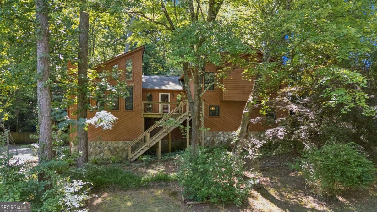 Situated in the beautiful Peachtree Walk community in North Gwinnett County, this split level home makes you fell like you're in a tree house! Welcome inside through the foyer to a Fireside Great Room & Dining Room with updated windows offering views of mature landscaping and plenty of trees. The Kitchen is equipped with upgraded appliances and has access to the private, wooded backyard and massive deck where you can enjoy that morning coffee or evening cocktail. Go downstairs to find an amazing Den with a bar, set up for those family movie nights or the big game. There is also a bedroom, full bath and laundry room on the lower level. Upstairs is the secluded Primary Suite with 2 Walk-in closets, Dual vanities, Whirlpool Soaking tub and separate Shower. Two additional bedrooms share a bathroom upstairs as well. The extra space in the garage provides plenty of storage and a workshop with work bench for all of life's projects. All of this is located in a serene community on over 3/4 acre in North Gwinnett with no HOA! Just minutes from TPC Sugarloaf, Suwanee, John's Creek & I-85.