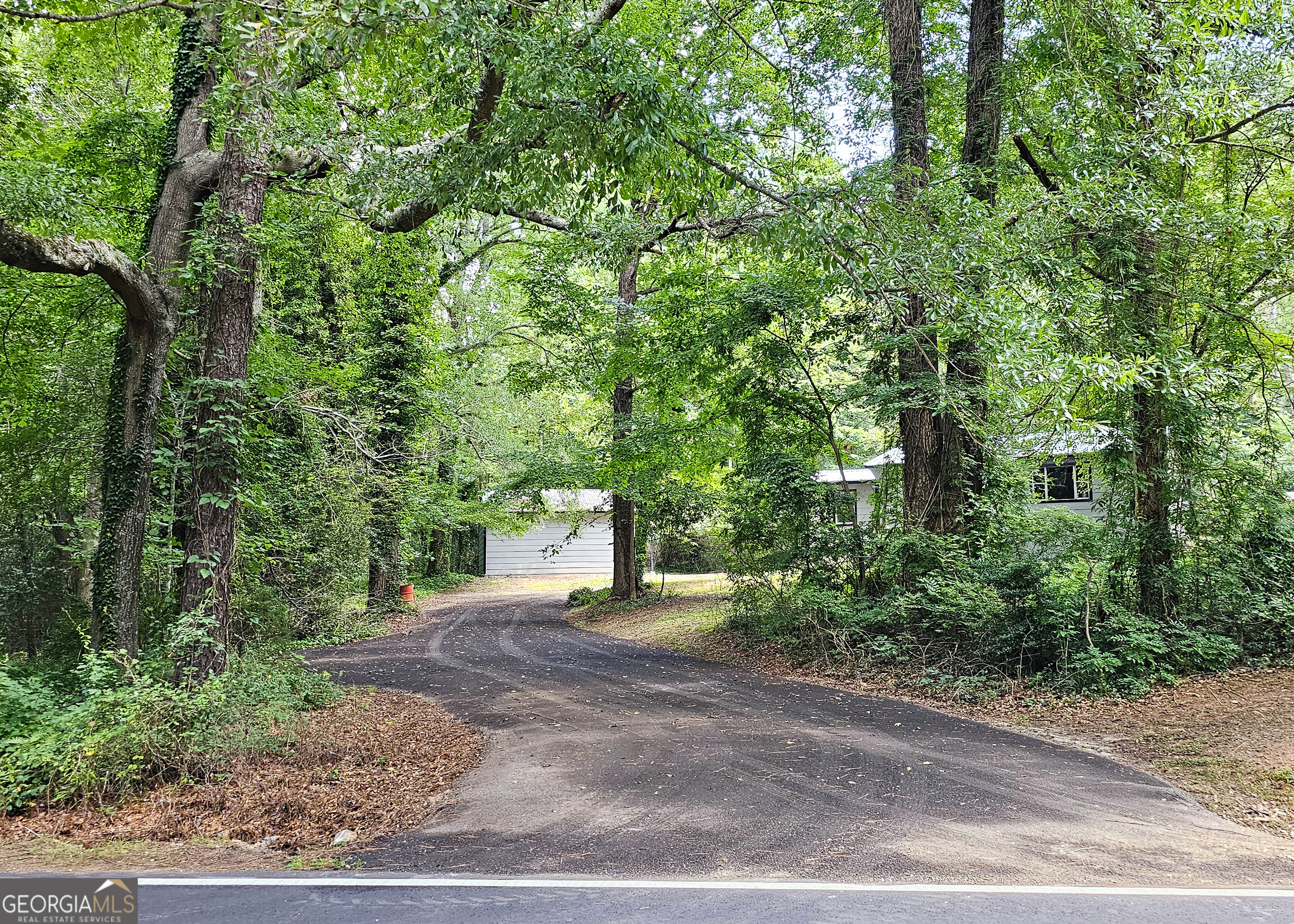 Wait till you see inside! This charming cottage on one level sits on a full acre homesite, it sits off the road among hardwood trees. You get a secluded feel as you ride up the driveway to the property. It has all brand new sheetrock, new flooring, new granite kitchen, and new stainless steel appliances. All the new finishes are color coordinated to show like a model home. The beautiful new granite kitchen with breakfast bar opens to a spacious living room. New stainless steel appliances include a dishwasher, stove & refrigerator and new sink. The closet in the kitchen has washer, dryer and water heater inside new bi-fold doors. The spacious tile bathroom has a new sink cabinet, new tile flooring and a traditional shower/tub combo. Extra shelving in the bathroom provides storage and a window allows for plenty of natural light. In addition to the breakfast bar, there's room for dining in the kitchen and/or the spacious great room. There are 2 decks, both in front and back. The kitchen opens to the back deck and parking areas. There's also a 30' x 30' out building with a brand new garage door. It can be used as a garage, work shop, storage area or whatever you need. Age of A/C is 2yrs, roof is 3 yrs. The full acre lot is bordered by woods in back and a small stream runs along the left side of the property. Convenient to Publix shopping, Cochran Park, restaurants and schools. Must see to appreciate. Photos coming soon! Please use Showing Time.