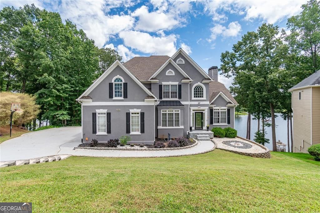 Lakefront Living at Its Finest! Meticulously maintained and beautifully updated, this home captures stunning lake views from the kitchen, living room, primary suite, and backyard. Relax or entertain on the spacious deck overlooking the water. Inside, the renovated kitchen shines with modern finishes and a brand-new upgraded dishwasher. The Great Room features cathedral ceilings, a cozy fireplace, custom curtains framing the view, and special recessed lighting for a warm, upscale feel. The primary suite is a private retreat with its own fireplace and a completely updated spa-style bathroom, showcasing a new custom upgraded bathtub and shower plus designer touches throughout. A main-level bedroom with a full bath adds convenience for guests or multi-generational living. Thoughtful extras include new storm doors, professional landscaping, a two-car garage, an unfinished basement with ample storage, a tankless water heater, and an EV charger. Set in a sought-after community close to shopping, dining, and amenities-this lakefront home is in great shape and truly a must-see!
