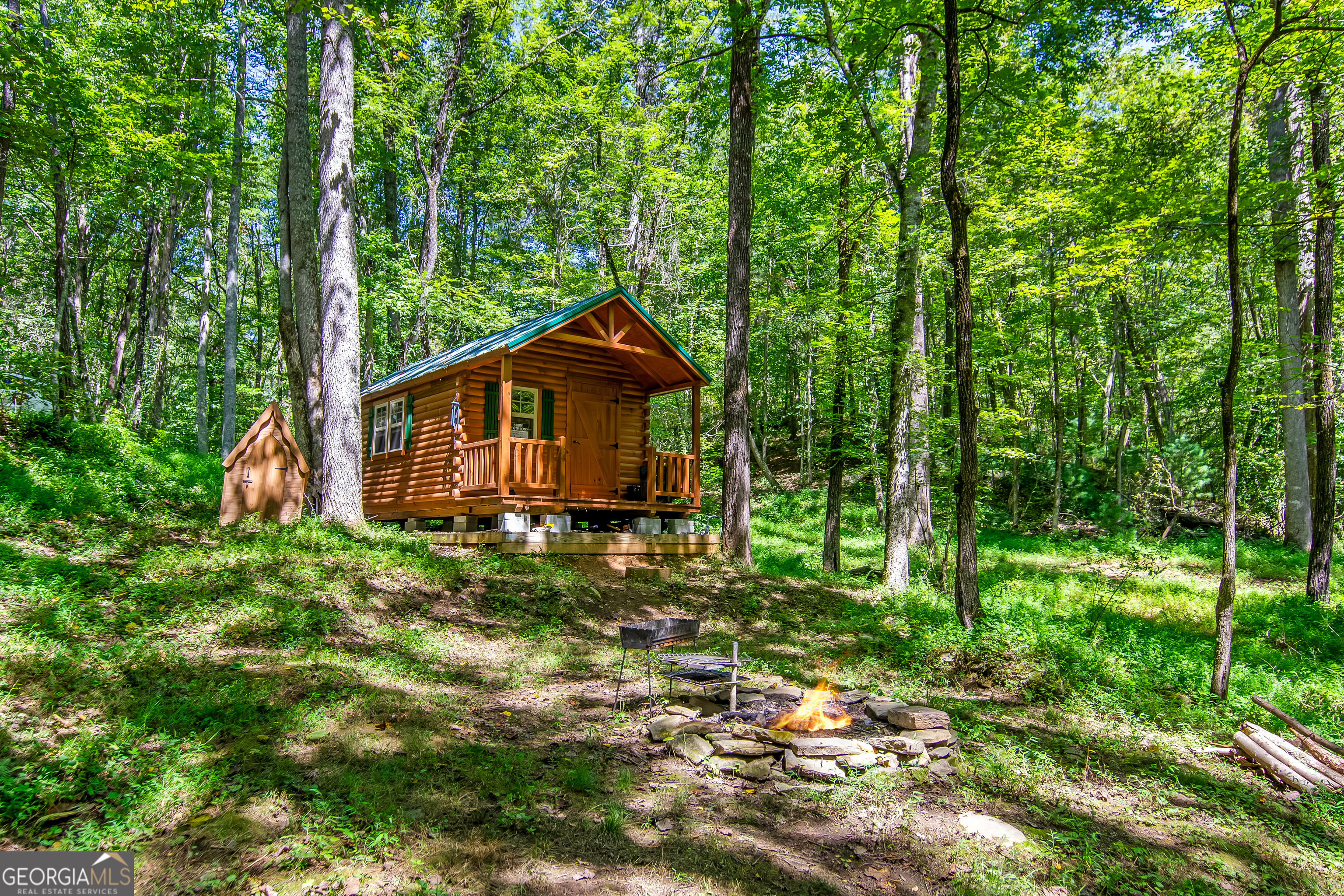 Discover 7.7 acres of pure privacy in the heart of Ellijay! This unique property is unrestricted with no HOA, offering complete freedom to use it as you wish. A creek flows through the property with several flat, usable areas along the water, creating multiple scenic spots to relax or build. With 4-5 potential building sites and road frontage all the way around, the options are endless for building your dream home, family retreat, or multiple cabins. The property already includes a 12x24 hunting cabin built in 2024, featuring double pane windows, AC (window unit), solar power with a generator backup, and fresh spring water that is drinkable. Inside you'll find a bedroom area, sink ready for water hookup, mini fridge, electric cooktop, and storage space, making it a cozy camping home while you build. A firepit is in place for gatherings under the stars. The land has a recent survey, and R1 zoning, making it ready for your next step. With excellent cell service, power nearby, and unrestricted use, this property is perfect for those seeking a weekend getaway, hunting retreat, log cabin build, or full-time residence in a quiet, natural setting.Map GPS to 260 Oak Hill Drive, Ellijay GA 30540. From here, when you see this home on your R, take a left directly across the road onto the old road bed. Follow road for about 1/4 a mile and see the property on the right. Sign in place. From Walmart Ellijay, head out of the parking lot and take Highland Xing to merge onto GA-SR 5 / SR 515 South. Follow SR 515 for about 1.6 miles, then turn right onto GA-SR 382. Continue along SR 382, and when you reach the roundabout, take the second exit to stay on SR 382. In 5.3 mi, turn R onto Oak Hill Rid. In 1.7 mi, turn L onto Oak Hill Drive. When you see 120 Oak Hill Drive, Ellijay GA 30540 on your R, take a left directly across the road on the old road bed. See property in about 1/4 mile on the right. Signs in place. Property lines are marked with ribbons all the way around, but Use landglide for property lines accuracy.
