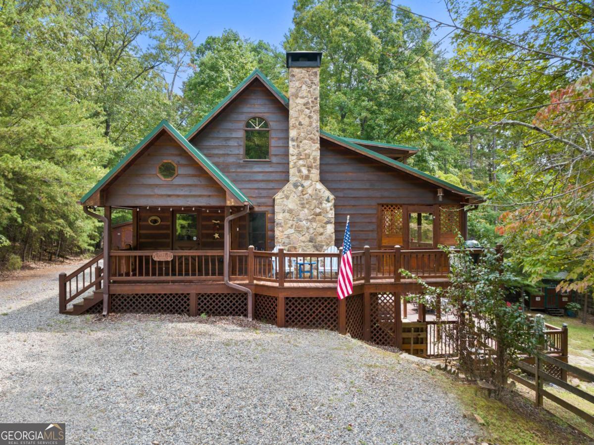 Rustic Charm Meets Modern Comfort - 55 Trails End Lane, Morganton, GA Discover the perfect blend of privacy and convenience in this 3 bedroom, 3 bath log-style home, nestled on nearly 7 acres at the end of the road. Surrounded by nature, this property offers the ideal mountain retreat. Step inside to an inviting all-wood interior, complete with soaring ceilings, a cozy vented gas fireplace, and an open layout filled with natural light. The kitchen features granite countertops and stainless steel appliances, flowing seamlessly into the dining area. A spacious loft provides additional room for work or relaxation, while the master suite opens to its own private covered porch - perfect for morning coffee or quiet evenings. The finished basement offers a cozy sitting area, pool table for game time, and double bunk beds for extra sleeping space - making it a great spot for guests and family fun. Enjoy the outdoors on the expansive porches and decks, soak in the new hot tub, or take advantage of unique features like a fenced yard, 2 outbuildings, and even your own archery range. With a metal roof, public water, and furnished with just a few personal exceptions, this home is truly move-in ready.