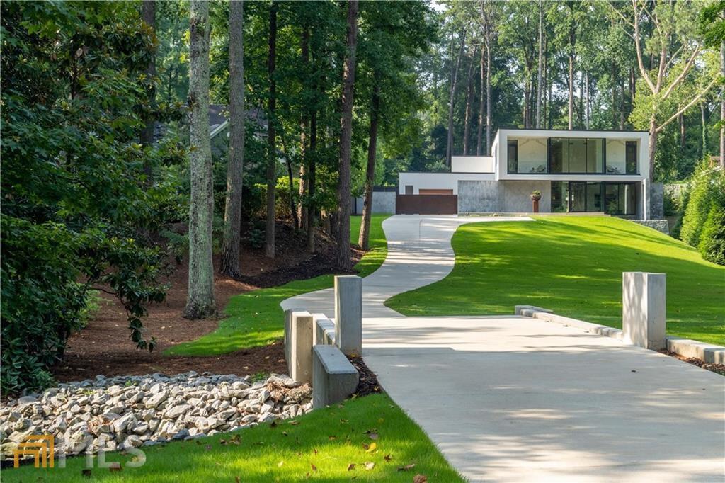 This listing is more than just another house to hit the market. This residence is an Experience- A Way of Life. If you’re looking for a Peaceful, Tranquil home with clean lines, beautiful views, and privacy on over 1.5 acres- this is it. Outstanding location close to many cultural and social hubs with easy access to the airport. Extraordinary Custom-Built modern residence designed by Jeffrey Bruce Baker. Features a 10+ backyard oasis with a sun ledge heated pool, raised black glass infinity spa & free-standing pool bath cabana. This spectacular home enjoys gentle sounds of water from the reflection pond with 2-story glass wall & glass pivot front door. The centerpiece of this house is the large great room with 20ft ceilings, dramatic Granite & Steel floating fireplace, 6-paneled sliding glass doors- seamless indoor/outdoor livability. Gourmet kitchen features a Butler’s pantry with stone door, custom cabinetry, separate prep area, Compac counters & stone slab-clad walls overlooking the outdoor eating area with a screen & fireplace. Rare, master on main, enjoys access to the pool, opulent, oversized closet & dressing room with custom cabinetry & many storage spaces. The master suite bath enjoys multi layers of white materials/textures for a sleek look. Attached in the master suite is a separate office designed for maximum function & efficiency. Also on the main level is a media room/den/library & home gym. The second level features 3 guest suites-2 enjoy balconies with front yard views. Plus separate hangout TV area & rooftop terrace that overlooks the backyard. Other innovative & design features include a dramatic floating double staircase, Neolith porcelain, three-coat cement stucco facade, Pella windows, oversized 3-car garage & motor court with custom power gate. Featured in Architectural Digest Oct. '21 Issue! Be sure to check out the video.