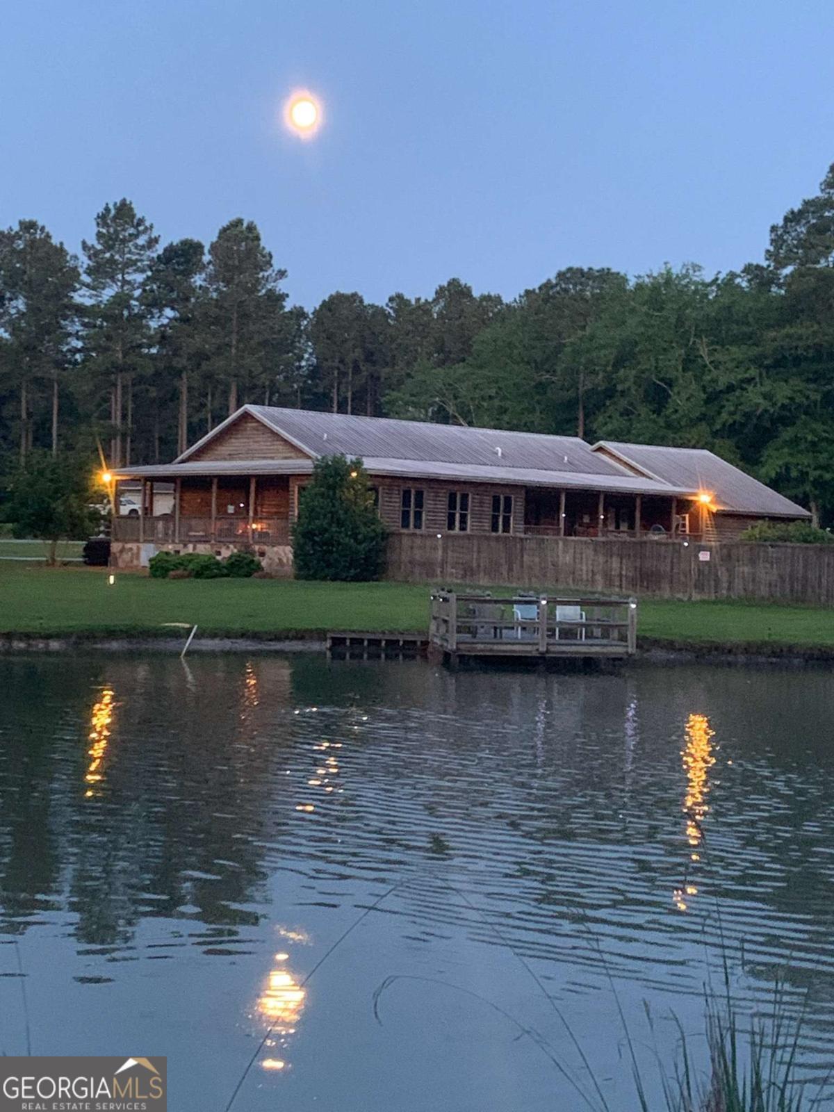 Nestled on 5.67 acres of tranquil land, this custom-built log cabin at 1293 Pine Ridge Dr in Claxton, GA, offers a perfect blend of rustic charm and modern comfort. Built in 2012, the home features 2,036 sq ft of thoughtfully designed living space, including 2 bedrooms and 2 bathrooms. The open-concept layout is highlighted by a spacious family room with vaulted ceilings and a stone fireplace, creating a warm and inviting atmosphere. The kitchen boasts custom cabinetry, granite countertops, and stainless steel appliances, ideal for both everyday living and entertaining. Additional spaces include a sunroom, laundry room, and a den, providing ample room for relaxation and hobbies.