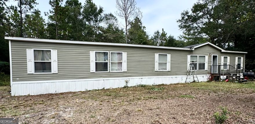 This spacious 4 bedroom, 2 bath mobile home features two living areas, a large spacious kitchen with island and pantry, separate dining room, laundry room, a large primary bathroom with double vanity, soaking tub, shower and huge walk in closet!  This mobile home sits on 3+ acres of land and offers the ultimate opportunity for privacy. Please note exterior picture is NOT a current picture of home due to needed yard work. More pics to come. The mobile home does have vinyl underpinning.