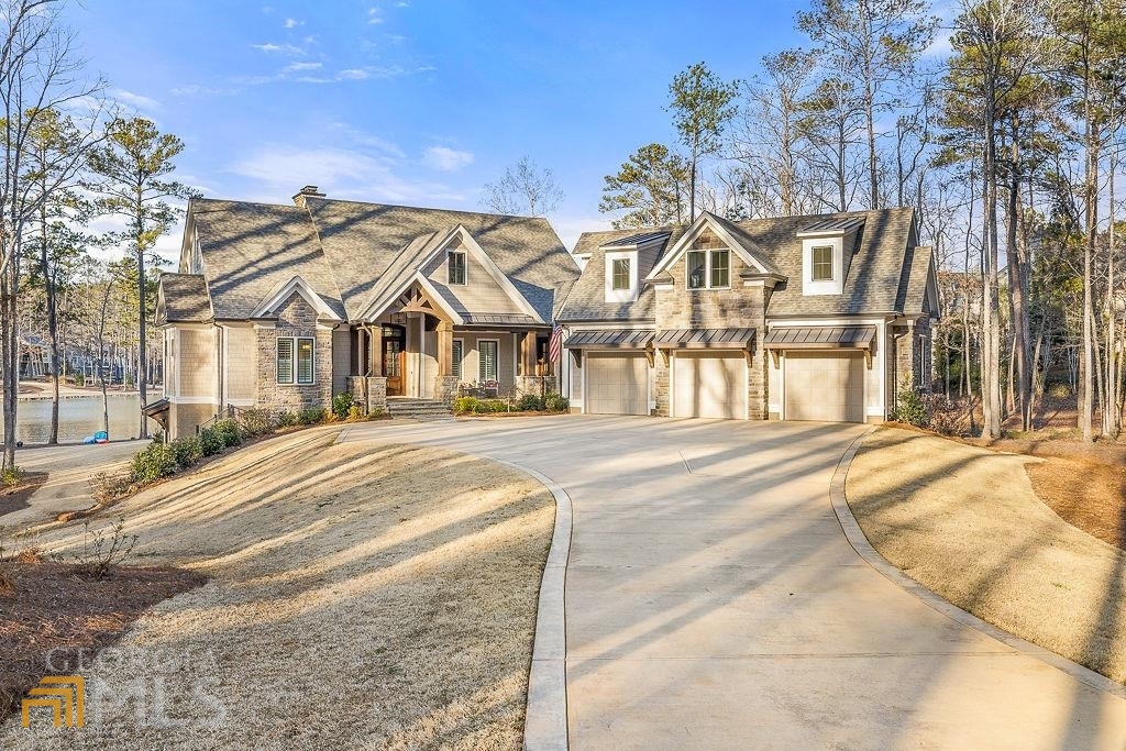 This amazing Reynolds lakefront property in the sought after Jackson Ridge area offers complete and total privacy. This idyllic estate lot is a rare find from its long meandering driveway on almost an acre and a half of property and boasting over 300' of shoreline offering big lake views. Enjoy lounging by the pool or sitting on your max dock with friends and family and feel like you don't have a next door neighbor. This area of the lake has some of the clearest water and is a quick trip by boat to The Lake Club and The Ritz Carlton. Built in 2020 this home is a must see. This five bedroom, five and a half bath retreat is tastefully appointed throughout. From the great room, with cathedral ceiling, hard wood floors, cedar beams, enormous stone fireplace and wall of windows and doors which open up to a stunning covered patio with giant lake views and wood burning fireplace. To the light filled kitchen and dining room with extensive ship lap detailing which flows from the great room making it perfect for entertaining! Additionally, the laundry room boasts and an abundance of cabinetry and is situated off of the kitchen. Wake up to coffee on your patio and enjoy the views from the main level owners suite which features ensuite bath and his and her closets. An office near the entry offers a quiet place to work with glass paned doors to keep up the with comings and goings. Other great features of this home include: Finished basement with wet bar, den with fireplace, 4 guest bedrooms (one with built in bunk beds), a home gym, bonus room, full length covered patios both on main level and ground with wood burning fireplaces, salt water pool and hot tub, extra large level backyard lawn, max dock with boat lift and 2 jet ski bays, 3 car garage and extra storage space that either could be finished for additional space if needed and has been stubbed in for elevator.