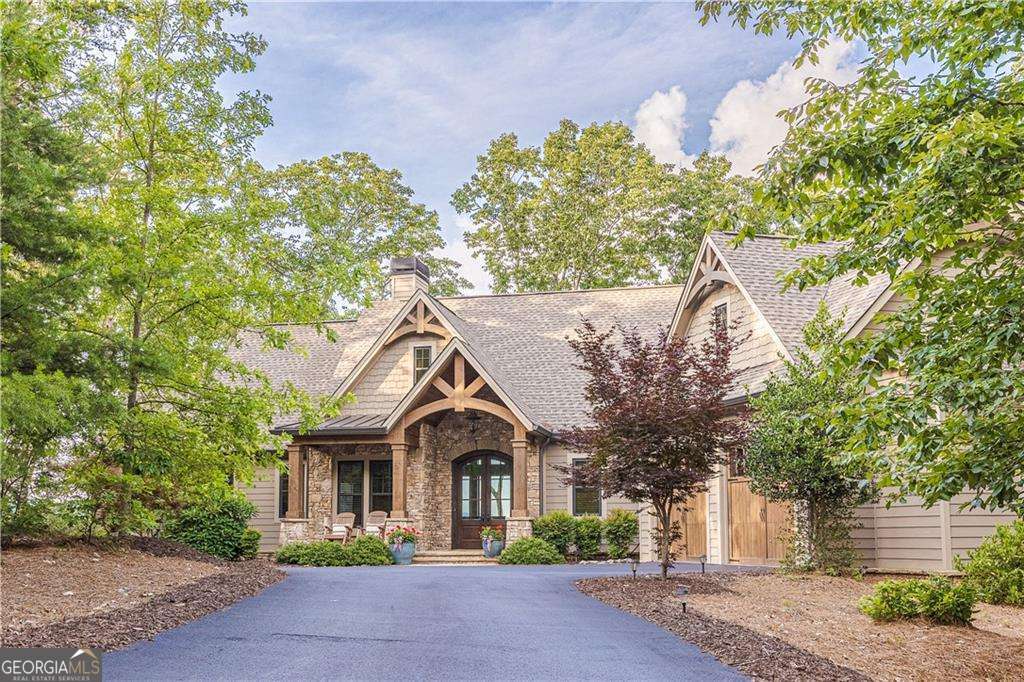 Nestled within the heart of Big Canoe's stunning mountain enclave, 331 Bluestern Drive offers a masterful blend of refined craftsmanship, breathtaking views, and the vibrant community lifestyle that makes this neighborhood so special. The setting and view will captivate you the moment you arrive. As you pull into the driveway-located on one of Big Canoe's most desirable streets and just minutes from the North Gate-you'll be greeted by sweeping vistas that stretch to the north and east. From the iconic Amicalola Falls to the rolling expanse of the surrounding Blue Ridge Mountains, every angle offers a view you'll never tire of. Inside you'll find quality craftsmanship and thoughtful design shine in every detail. Vaulted ceilings, rich wood beams, and stone accents create a warm yet sophisticated mountain retreat, while expansive windows and generous outdoor living spaces invite the surrounding beauty indoors. Beyond the home, life at Big Canoe is a rare blend of adventure and tranquility. Explore 20+ miles of hiking trails, discover hidden waterfalls, or take in the serenity of three private lakes. With more than 50 community clubs-from golf and tennis to fitness, boating, and social events-there's always something to enrich your days. 331 Bluestern Drive isn't just a home; it's a gateway to a lifestyle that celebrates nature, craftsmanship, and connection. Whether you're looking for a peaceful retreat or a home that keeps you active and engaged, this mountain sanctuary delivers it all. Don't miss your opportunity to own this custom home built by Dan DeJiacomo, who is also the listing agent. Schedule showing directly with Dan on an appointment basis only.