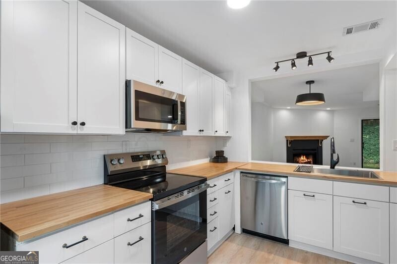 Welcome to this incredible find in the heart of Alpharetta! Freshly updated with brand-new flooring, lighting, kitchen appliances, butcher block countertops, and cabinets, this home is a rare opportunity at this price point and in this LOCATION. With no rental restrictions, this is a turn-key choice whether you're looking for your Alpharetta hideaway or an investment property. The main level features a large single-basin sink overlooking the great room, a cozy fireplace, generous ceilings, and sliding doors that open to a private back patio. Upstairs, both bedrooms are well sized with ample closets and en-suite bathrooms; one featuring a private balcony. LVP flooring flows throughout the main level, with plush new carpet upstairs. This is a rare, affordable option less than a mile from downtown Alpharetta and just two miles from Crabapple in Milton, with access to some of Georgia's finest schools. Alpharetta's Farmers Market runs nearly year-round, with seasonal festivals and endless shopping and dining at Avalon, Crabapple, downtown Alpharetta, Milton, and Roswell's Canton Street, everything you love is just minutes away!