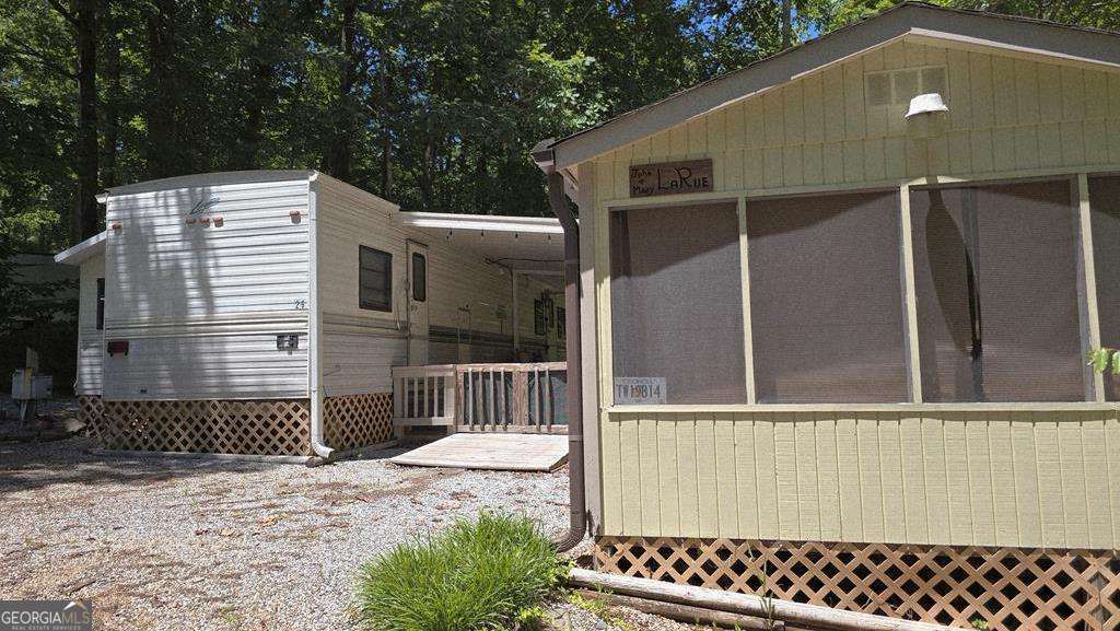 Welcome to your perfect getaway at 26 Terrace Circle in desirable Cleveland, GA! This well-kept camper offers 1 bedroom plus a bunkroom and 1 full bath, nestled within a vibrant resort community. Enjoy outdoor living year-round on the spacious covered and screened-in porch-ideal for relaxing or entertaining. The property features a private main bedroom and a bunkbed room, perfect for guests or family. A wonderful opportunity for a weekend retreat or seasonal living in the North Georgia mountains! **There are requirements related to how long you can stay at the property each year so you will need to check the restrictions and verify with HOA.