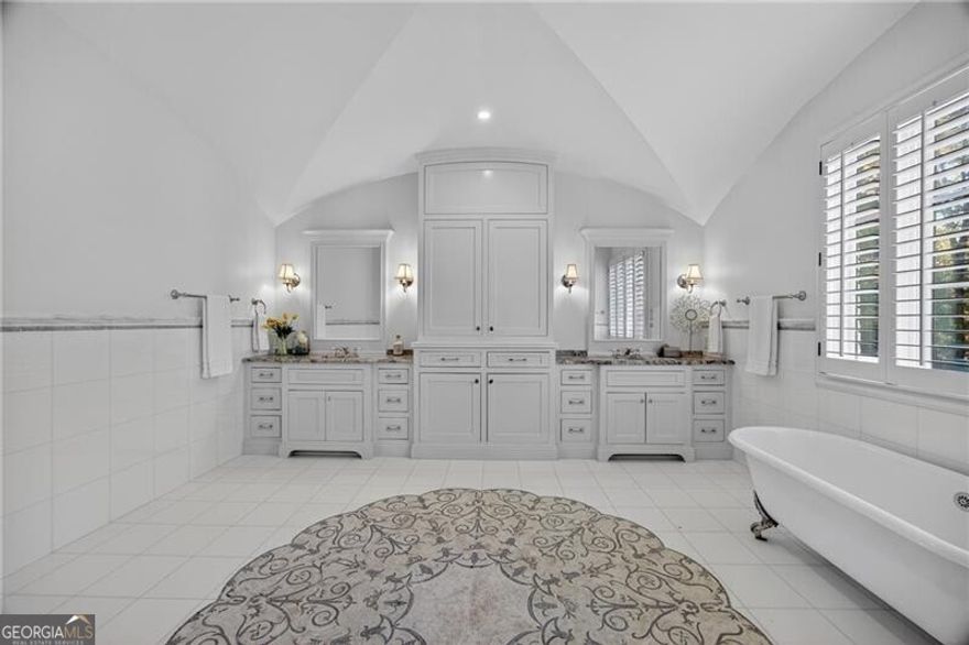 Located on a quiet cul-de-sac in one of Buckhead's most coveted neighborhoods, this stunning custom home combines timeless architecture with modern luxury. Behind stately gates, the residence features elegant symmetry, a slate roof, and beautifully landscaped grounds. Inside, light-filled living spaces showcase exceptional craftsmanship, from arched French doors to rich millwork and designer finishes. The chef's kitchen impresses with marble counters, professional-grade appliances, and a striking copper hood, huge granite island opening to inviting living and dining areas. The fireside primary suite on the main level offers vaulted ceilings and a spa-like marble bath with dual vanities and a soaking tub. Multiple terraces overlook the private, wooded backyard with a heated pool, creating a perfect setting for entertaining and relaxation. Newly refinished dark walnut hardwoods flooring and fresh paint throughout. Finished daylight terrace w/ bed/ bath, large flex space, storage, bar area. This exceptional home blends privacy, sophistication, and proximity to Buckhead's best shopping, dining, and top-rated schools.