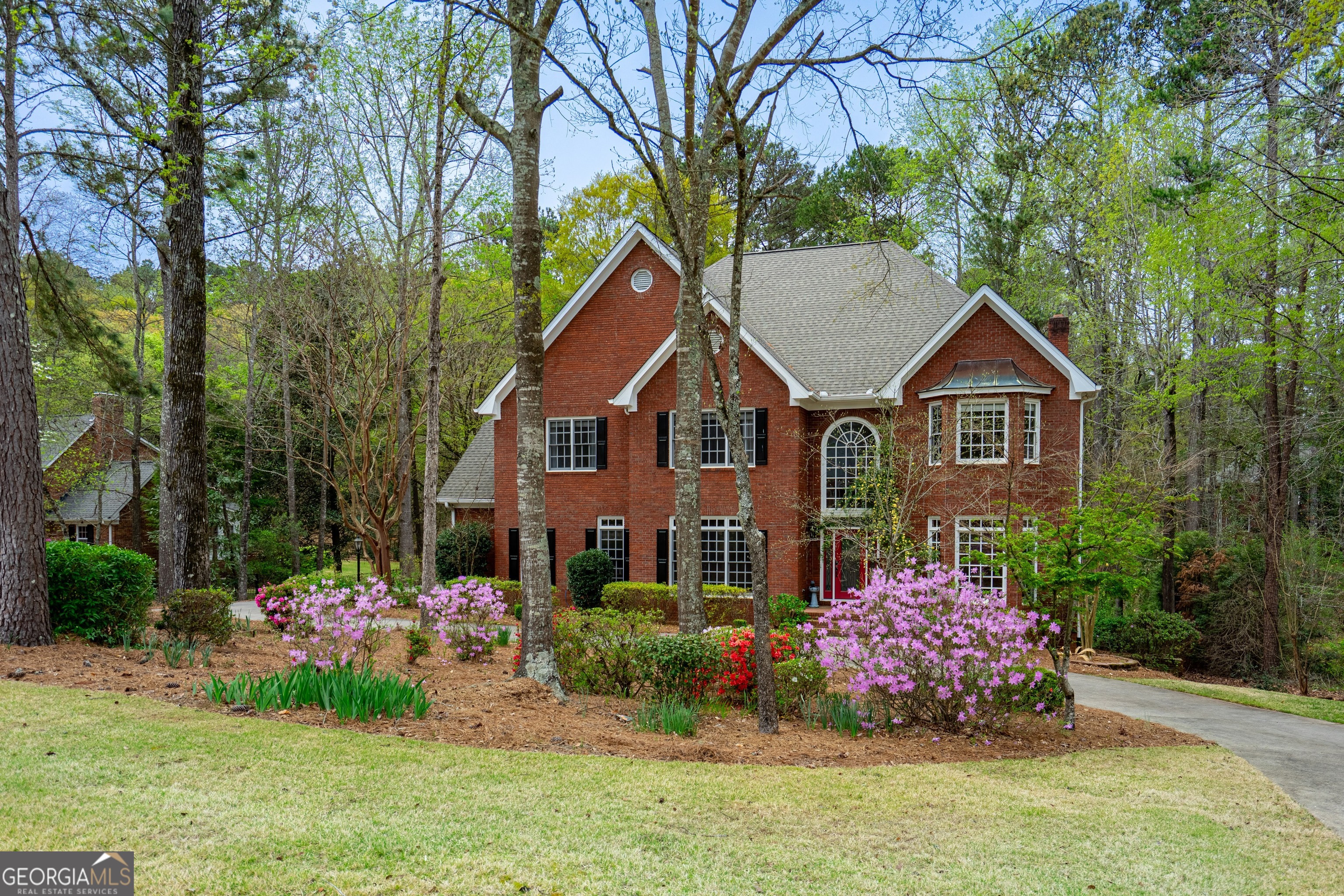Stunning, well kept all brick home in popular Moss Creek S/D, a premier lake community inside Lagrange City Limits. Enter through the beautiful 2 story foyer with separate extra large dining room and formal living room on main level. Hallway leads to a huge family room with high ceilings, fireplace and bookcases with abundant sunlight from large windows. French doors lead to a beautiful back deck with retractable awning for comfort and shade. Open floor plan leads into an extra large kitchen plus eat in breakfast area with lots of windows overlooking a beautiful private backyard. Kitchen has storage closet, island and abundance of countertops to make this your dream kitchen! Also on main level is a half bath, laundry room and storage room with plenty of space for ample storage area. Upstairs features 4 bedrooms and 3 full baths. Oversized master bedroom suite includes a large, beautiful master bath with separate shower and large his and her closet. Other bedrooms have adjoining baths. Home also includes a full basement with additional 5th bedroom with full bath, family room with fireplace opening up to a patio, game room/eating area and a mini kitchen. So many amenities throughout including numerous closets, hardwood floors, lovely landscaping, new roof, entry level garage, and back staircase. All this on a lovely landscaped yard. Moss Creek Subdivision has pool/tennis/pickleball available with clubhouse and community dock.