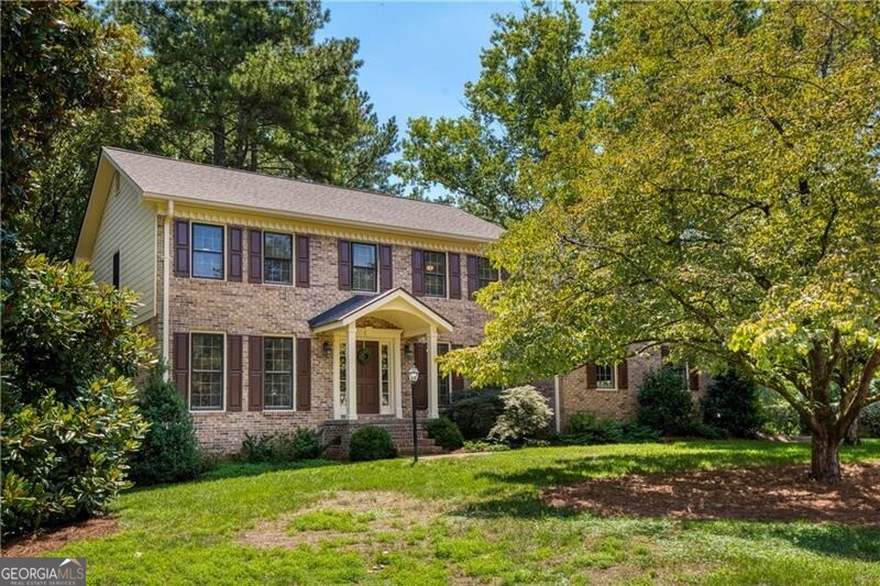 Set on a peaceful acre in the heart of Roswell, this well-built freshly painted 2-story home has been lovingly maintained since 1980, offering original finishes, a traditional layout, and a peaceful setting with a strong connection to nature. A new covered portico leads to the front entry, where the foyer is flanked by a formal living room and a main-level bedroom with full bath -ideal for guests, multi-generational living, or a quiet home office. The formal stairway rises just beyond, while straight ahead, the eat-in kitchen offers a central hub for daily living. To one side of the kitchen is a spacious formal dining room filled with natural light. On the other, the fireside family room offers a warm and comfortable gathering space, with access to the screened porch and private backyard. With an informal stairway to the upper level and direct access to the garage, the home's layout feels intuitive and well-planned. Out back, the screened porch opens to a private yard that feels like a nature preserve-complete with mature trees, statuary, and an abundance of birdlife. A garden shed offers space for tools or projects, and the 1-acre lot invites endless outdoor enjoyment for anyone who values nature, quiet and green space. Upstairs, the primary suite offers two closets and an ensuite bath, with peaceful views of the backyard. Two additional bedrooms share a full hall bath, and a bonus loft area adds flexibility for a playroom, homework station, or creative space. Ample storage is available throughout the home, including attic space, a large storage room off the garage, and a partial unfinished basement-ideal for a workshop, home gym, or seasonal organization. The oversized garage provides plenty of room for parking and storage, with convenient entry into the fireside family room. While finishes throughout the home remain largely original to the 1980s, the structure is solid and well-maintained-offering a fantastic opportunity for someone looking to renovate over time or make it their own from day one. Located less than a mile from Sweet Apple Elementary and Sweet Apple Park, and directly across from 50 acres of future green space recently acquired by the City of Roswell, this address is poised for long-term value. Enjoy the safety of sidewalks and streetlights, the ease of nearby shopping and dining, and a lifestyle that supports walking, biking, and connection to the outdoors. With new water heater, newer roof, no HOA and space to grow, 293 Walnutwood Trail offers the flexibility to move in as-is or a renovation opportunity with long-term upside.